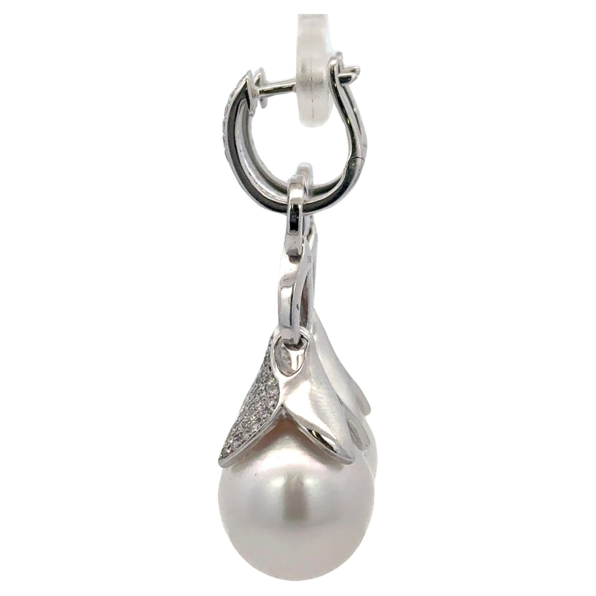 18 Karat white gold drop earrings featuring two South Sea Pearls measuring 13-14 MM with 188 round brilliants weighing 0.77 carats. 