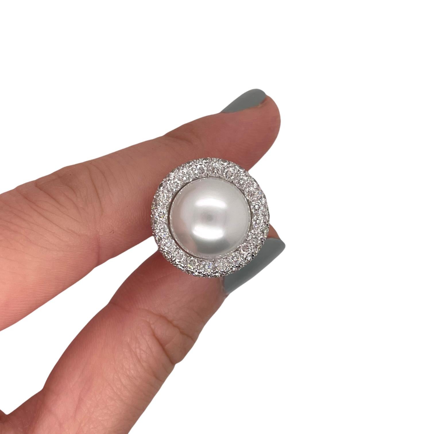 Earrings contain two 12.8mm South Sea Pearls and 120 round brilliant diamonds surrounding within a pave style halo, approximately 3.00tcw. Diamonds are near colorless and SI1 in clarity, excellent cut.  Earrings have a French clip post closure, all