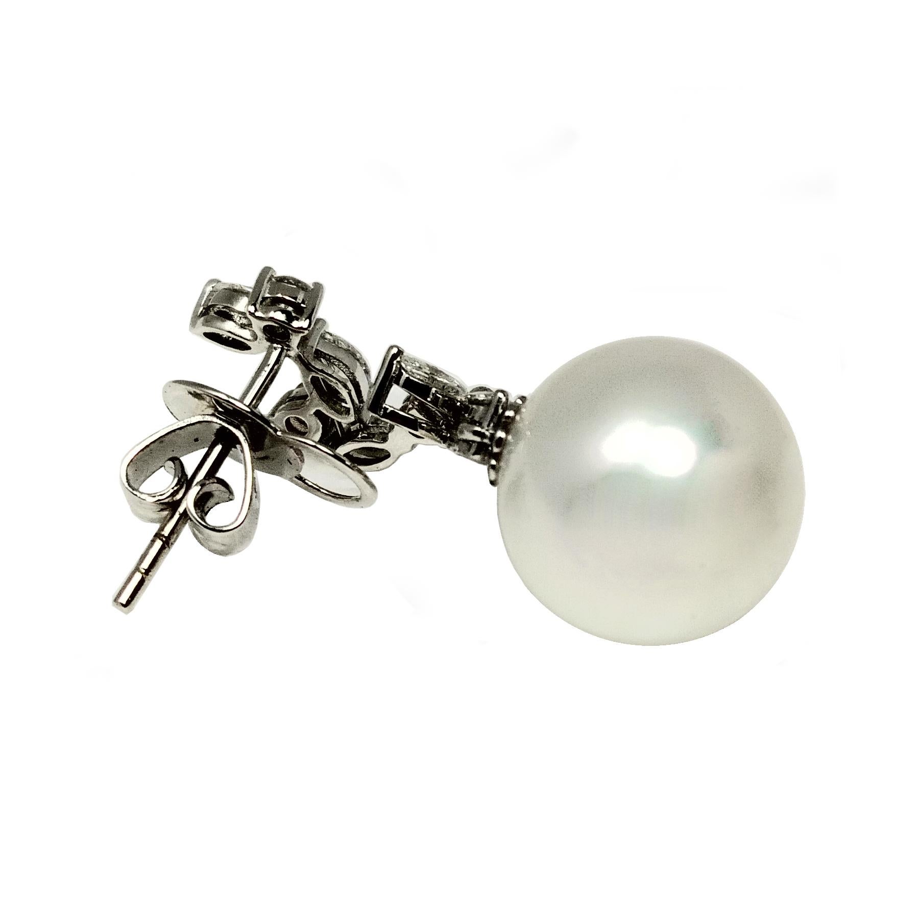South sea pearl and diamond dangling earrings. Handcrafted cultured white south sea matching pearls linked with marquise and round brilliant cut diamonds in asymmetrical dangling design in 18 karat white gold with push back butterfly post.

Pearl: