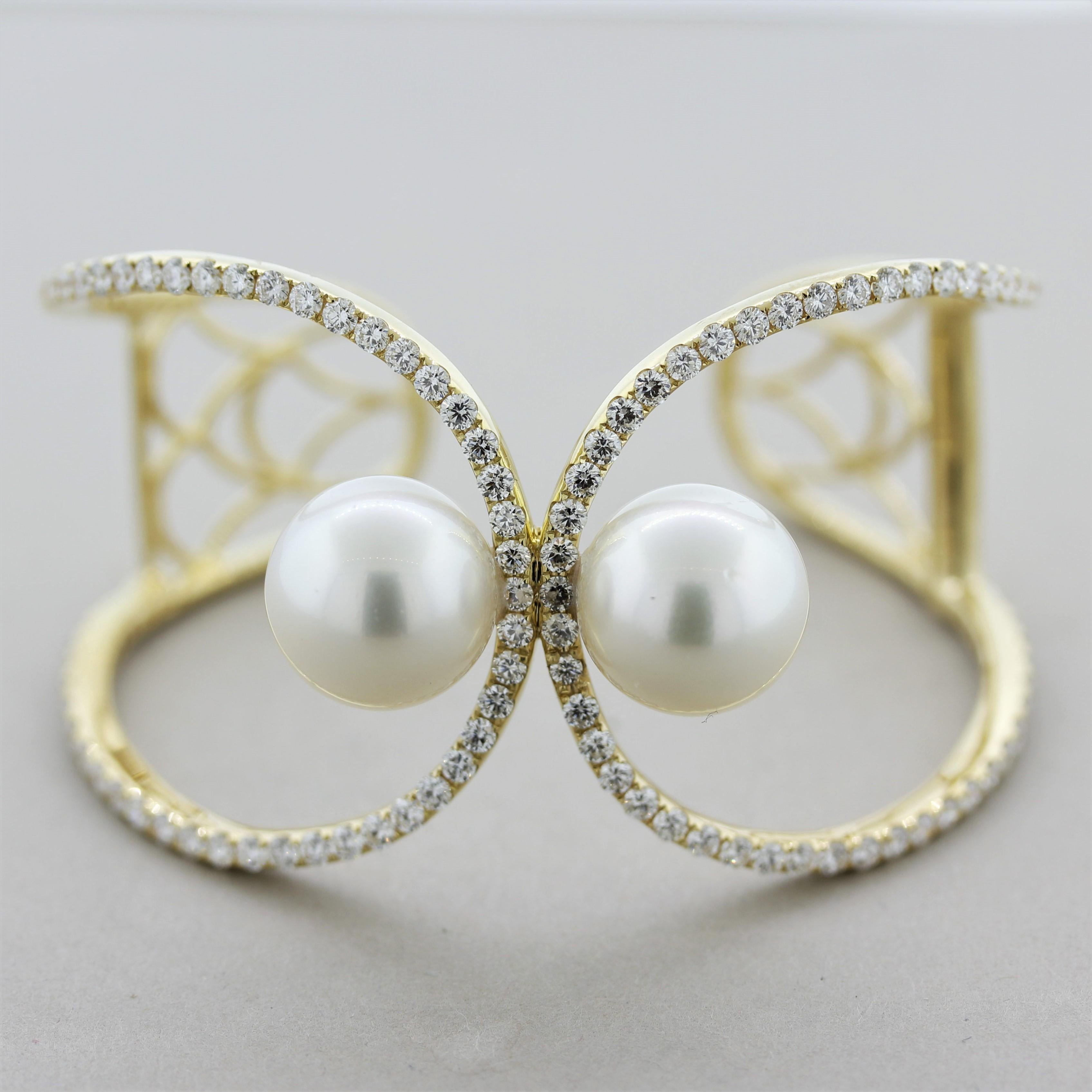A unique cuff bracelet featuring two round marching South Sea pearls measuring 14.5mm each. Running along the cuff are 4.72 carats of round brilliant-cut diamonds which add brilliance and sparkle to the piece. Made in 18k yellow gold and ready to be