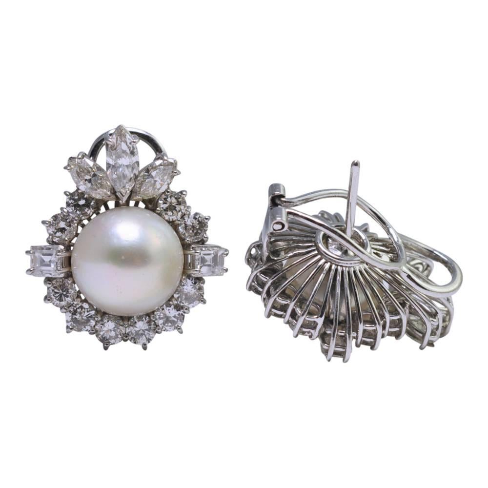 Spectacular large South Sea pearl and diamond earrings; each earring is set with a silvery 13mm South Sea pearl with strong lustre, surrounded by 3.33cts of marquise, brilliant and emerald cut diamonds all set over a wirework basket mount. Total