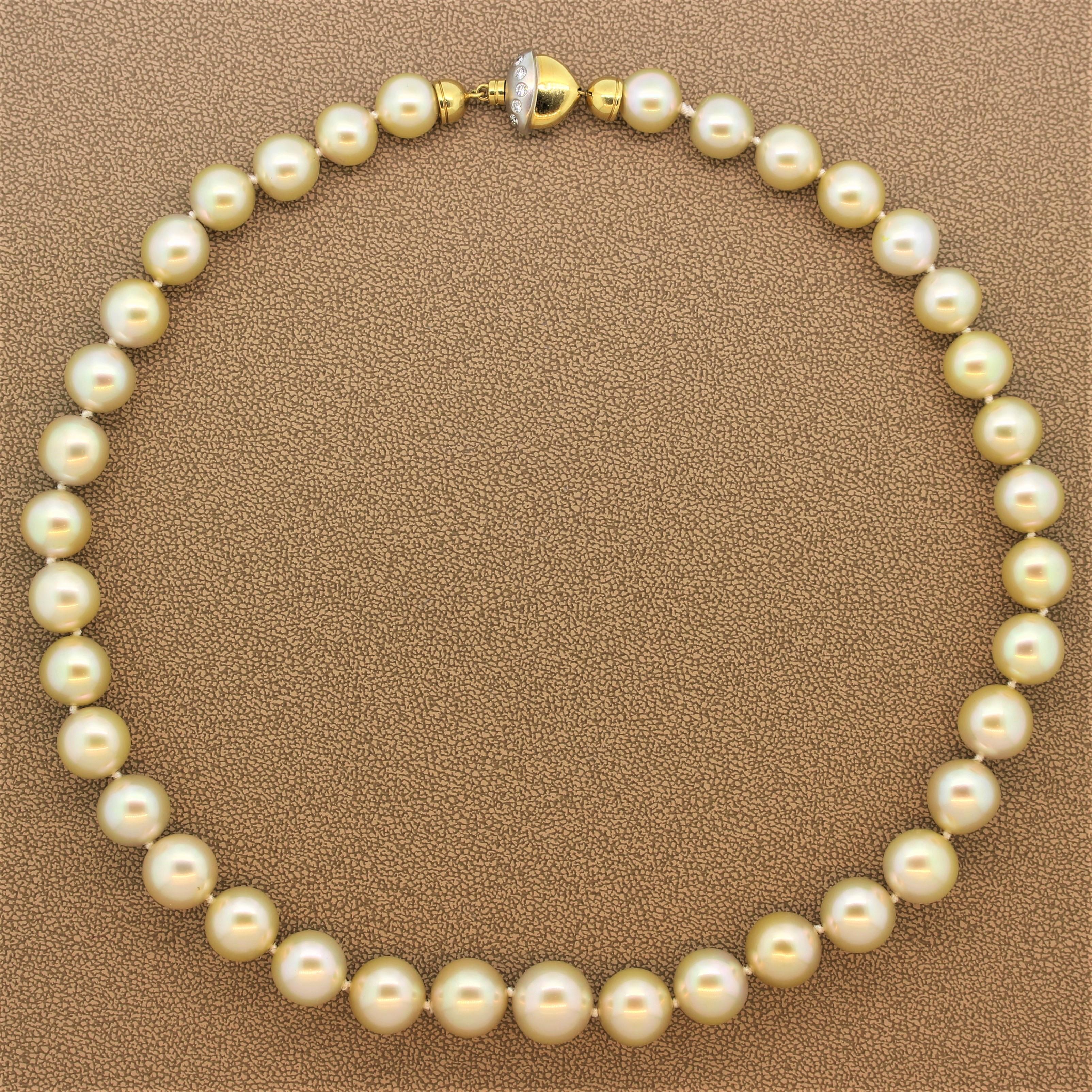 A beautiful golden South Sea pearl necklace featuring lustrous graduating gold pearls are free of dimples and dives which measure 13.65mm-10.50mm. The single strand necklace has a secure diamond studded lock of a two-tone 18K yellow and white