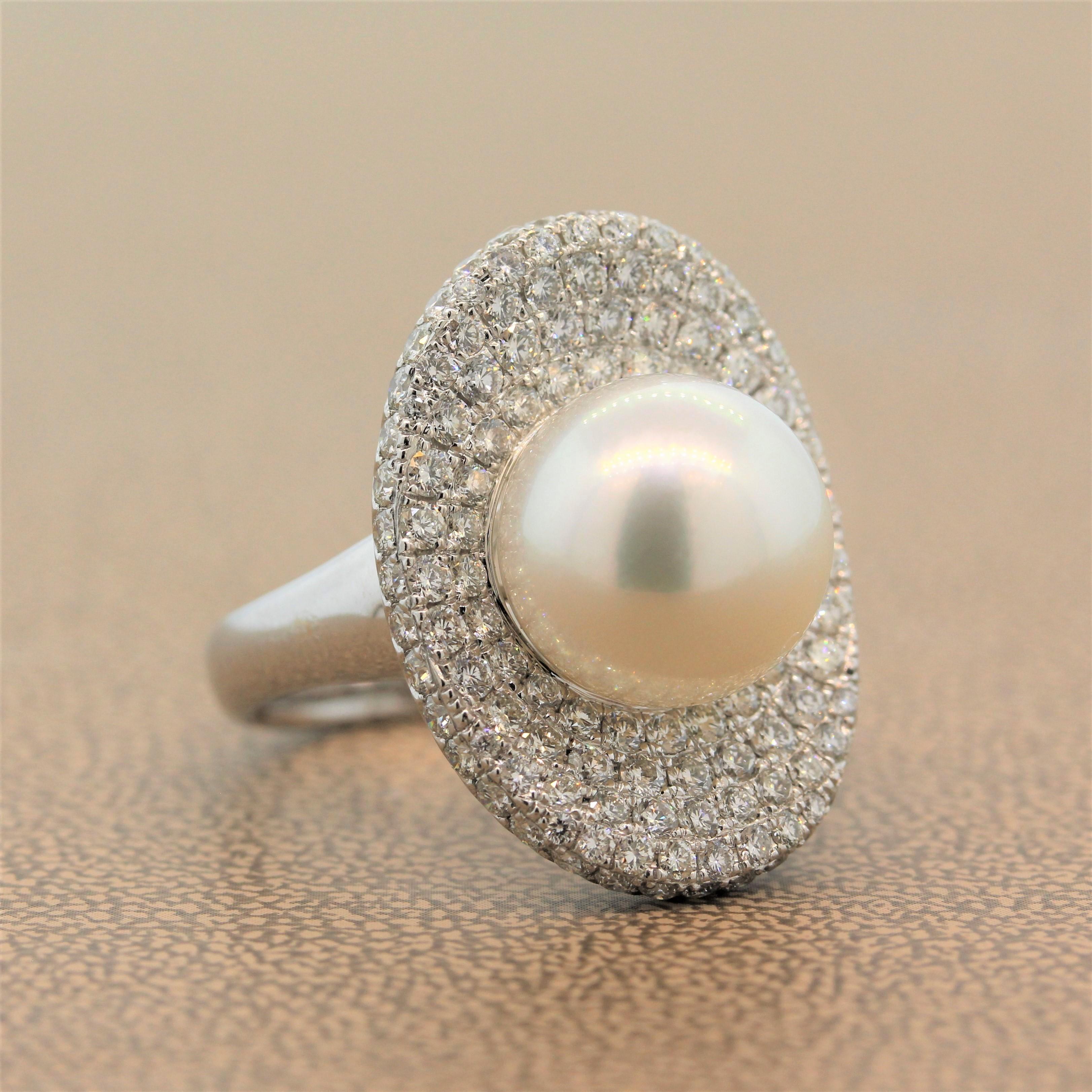 This characterful ring features a 12mm South Sea pearl in the center of a concave oval shape of this 18K white gold ring. The setting with 2.60 carats of shimmering round cut diamonds is reminiscent of a pearls shell. This cocktail ring is delicate