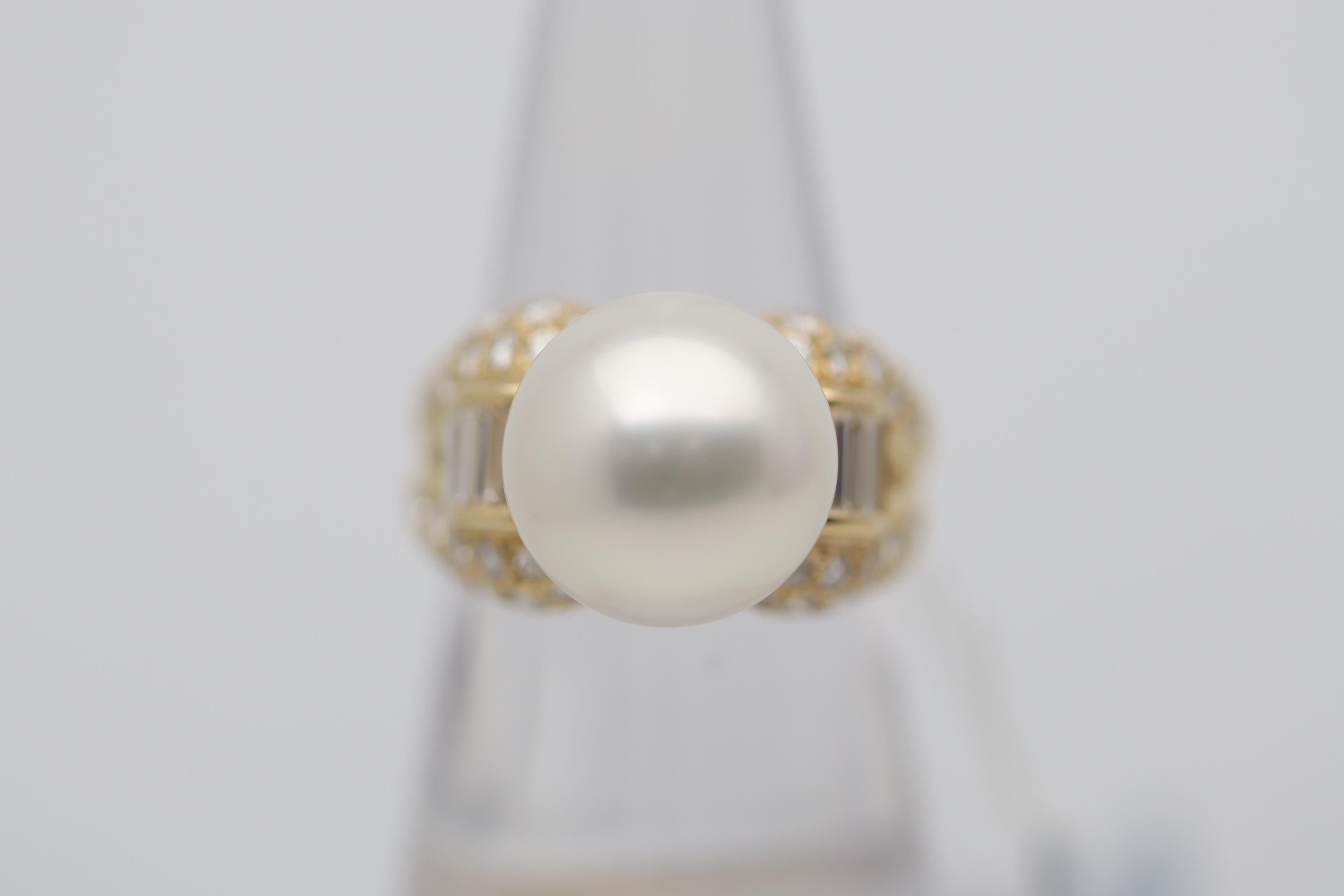 A lovely South Sea pearl takes center stage of the 18k yellow gold ring. It measures 13mm, is perfectly rounded, has excellent luster, and a soft pink overtone. It is complemented by 1.42 carats of baguette and round brilliant-cut diamonds set in a