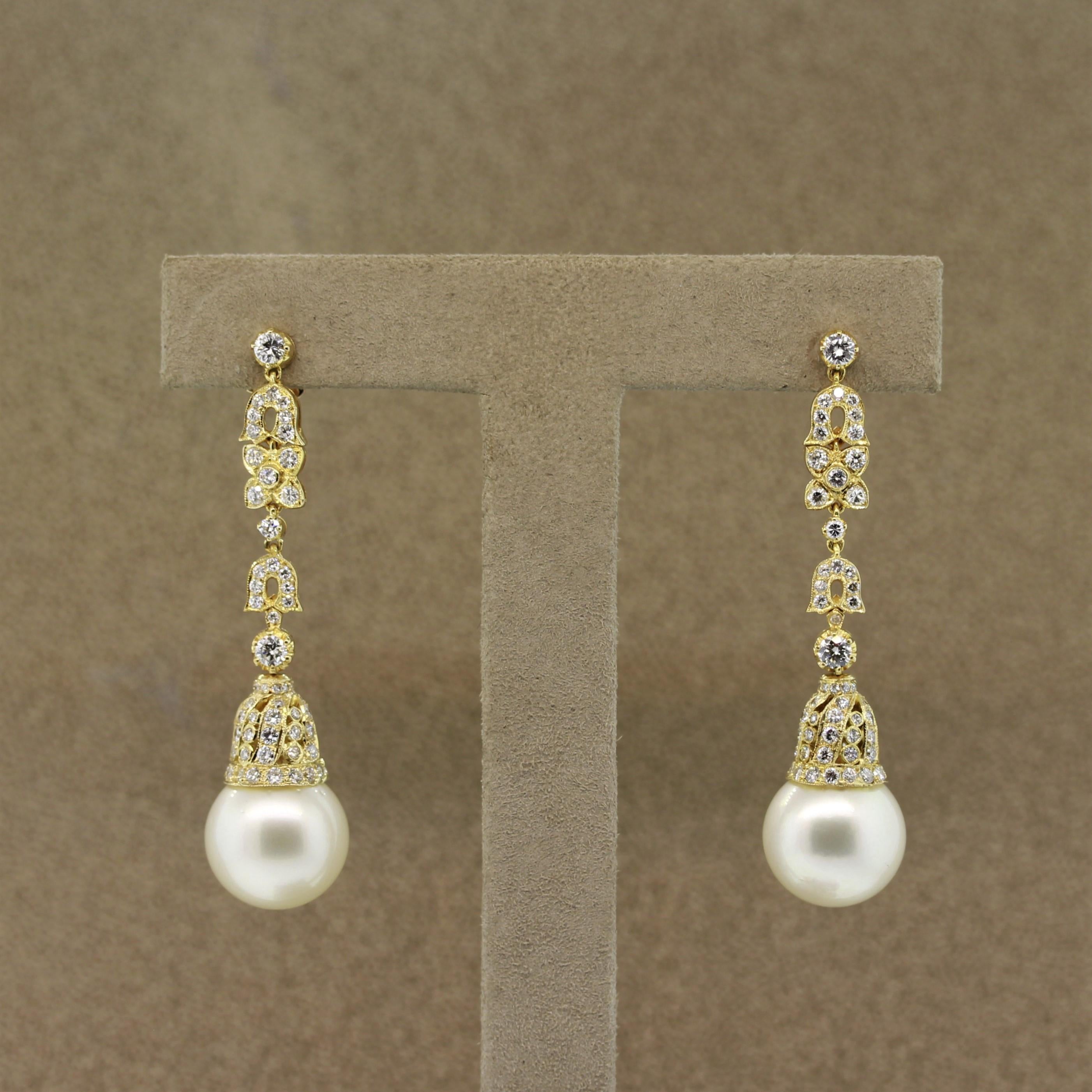 A stylish pair of earrings featuring 2 perfectly matching round South Sea pearls measuring 13mm each. They are accented by 2.46 carats of diamonds which run all along the drop portion of the earrings as well as around the setting of the pearls. Made