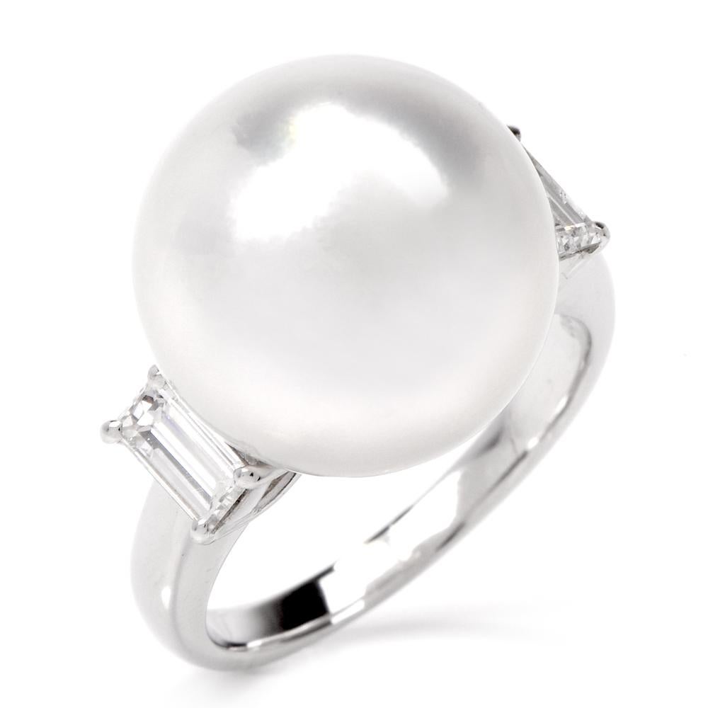 This estate cocktail ring of timeless elegance is crafted in solid platinum and weighs approximately 10.1 grams. The ring is centered with a lustrous 14.00 mm South-Sea pearl of silver white tone color. The highly ornate vintage style shoulders of