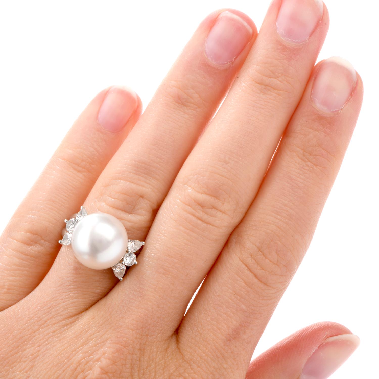 This alluring ring was crafted in Luxurious Platinum.

Prominently featured is one large 12mm round South Sea pearl with hints

of soft rose colored hues, bright lustre and minimal porosity.

Flanking the sides are 4 pear and 2 round brilliant cut