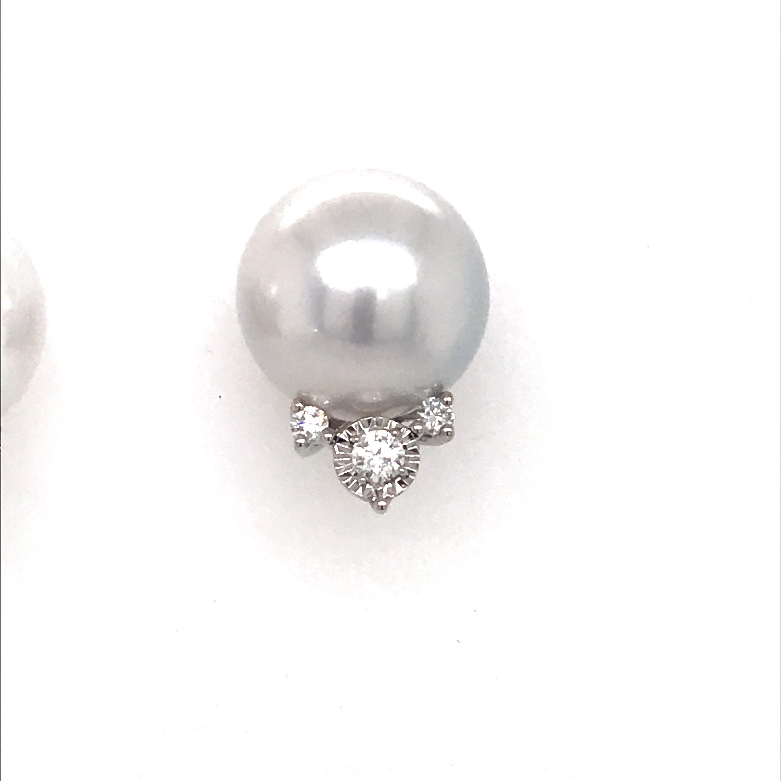 18K White gold stud earrings featuring two white South Sea Pearls measuring 14-15 mm flanked with two center diamonds weighing 0.19 carats and 4 round brilliants weighing 0.15 carats.
Color G-H
Clarity SI