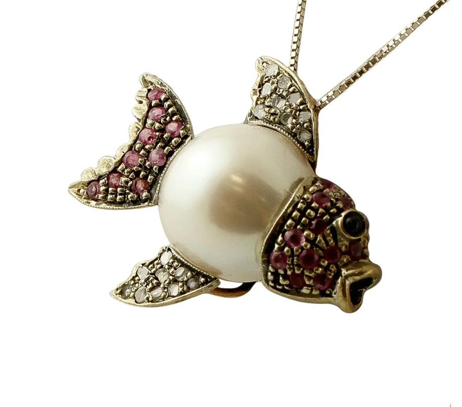 Vintage pendant in 9 karat rose gold and silver structure with fish design. The fish body consists of a south sea pearl (13mm) in the centre and silver structure studded with 0.12 ct of diamonds and 0.62 ct of rubies.
The origin of this pendant