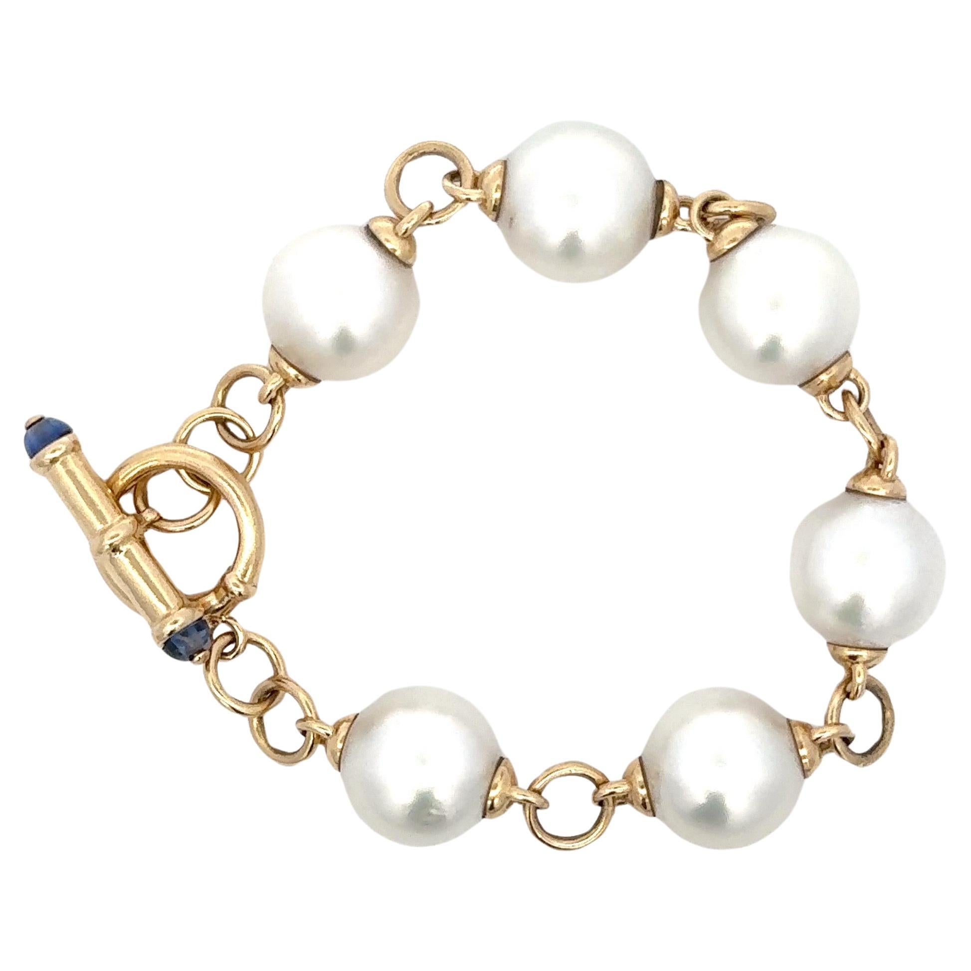 14 Karat yellow gold toggle link bracelet featuring 6 South Sea Pearls measuring 13.5 MM.
Cabochon Sapphire on Toggle Lock