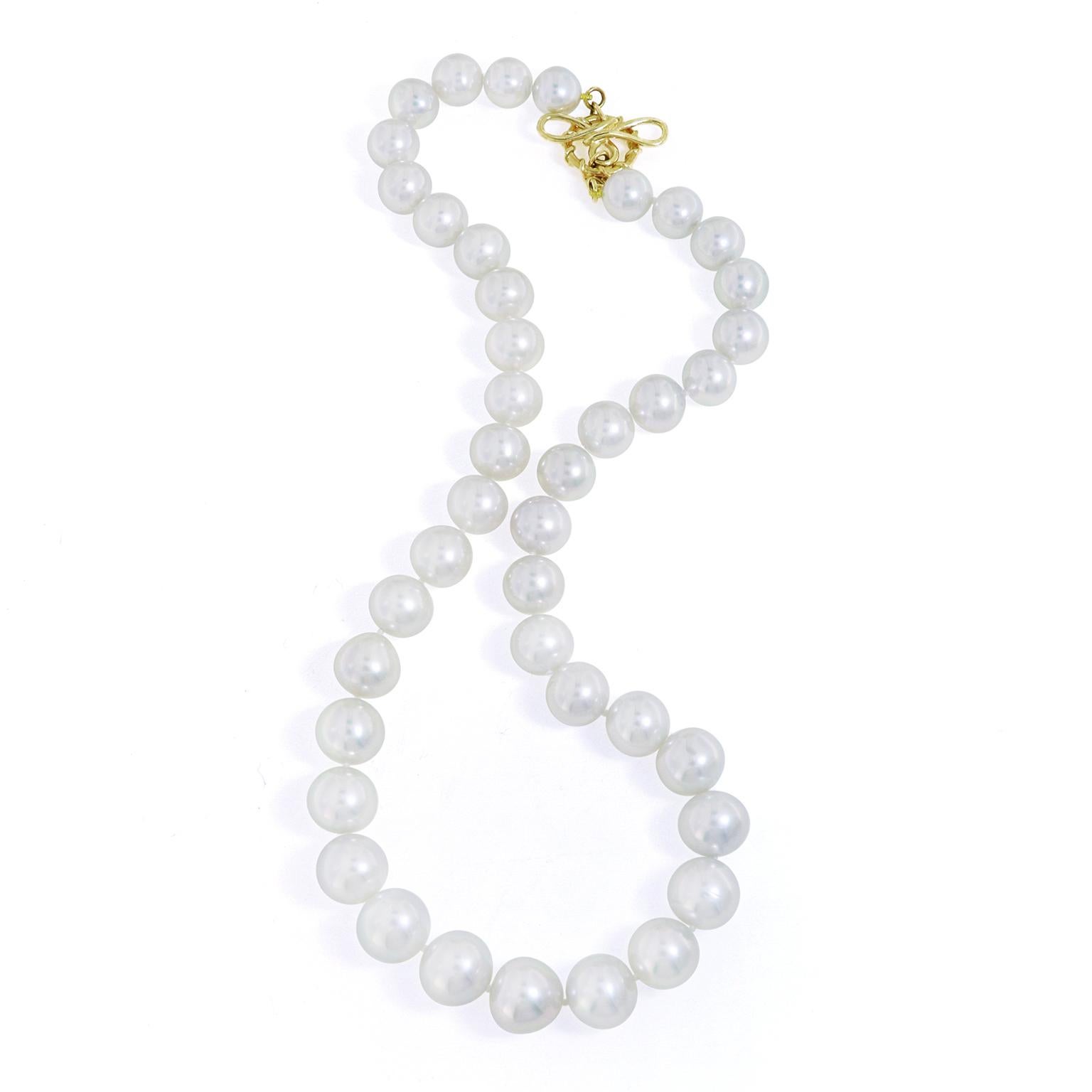 Lustrous radiance encompasses this elegant pearl necklace. 41 round South Sea pearls are strung together with a small knot in between each to ensure protection. The pearls gradually become more prominent in the center of the arrangement and descend