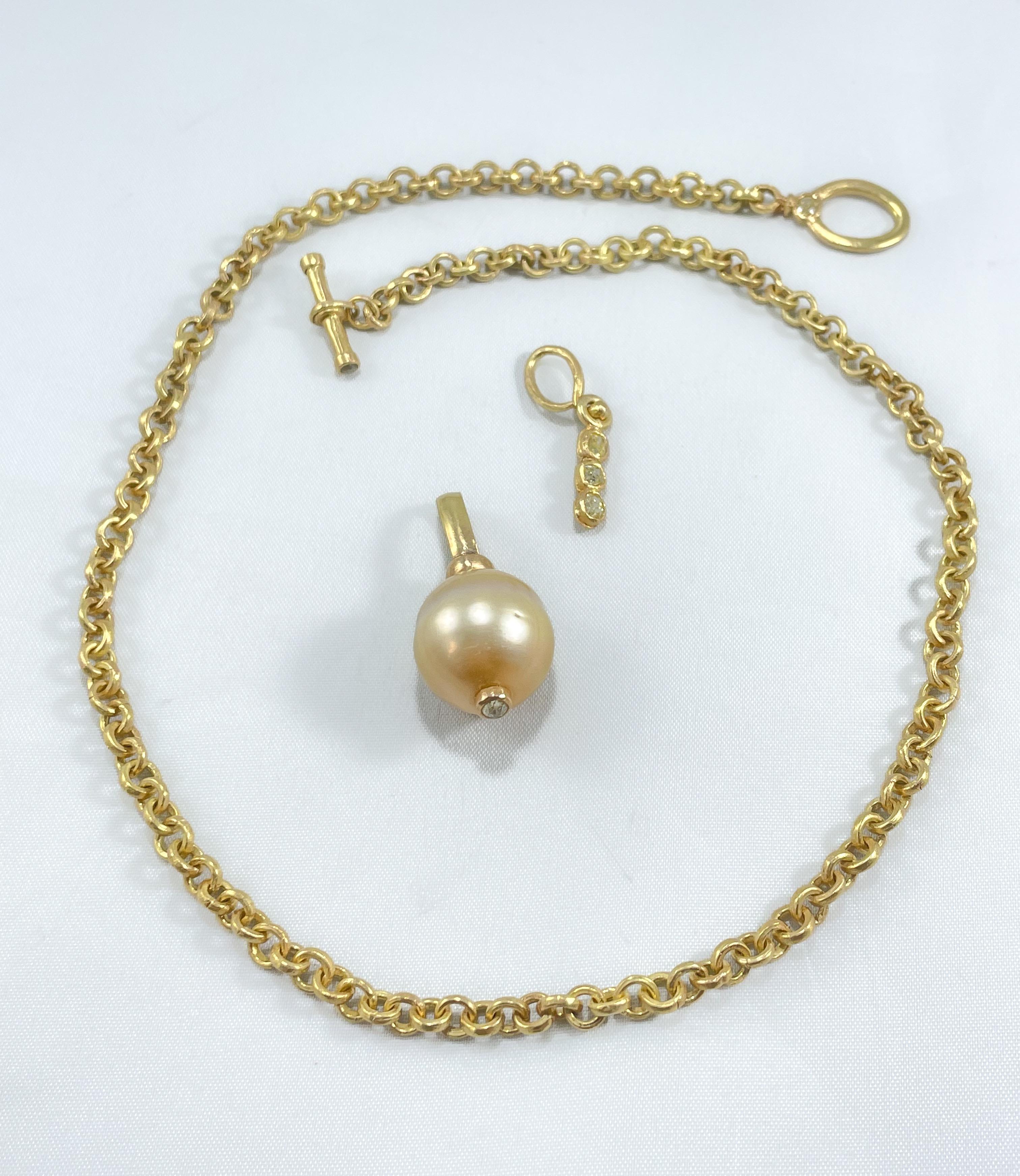 A large cream 17mm cultured pearl on a hand-crafted drop link necklace with a diamond enhancer. All are in recycled 18K gold. The necklace is made up of round uniformly shaped links. 18