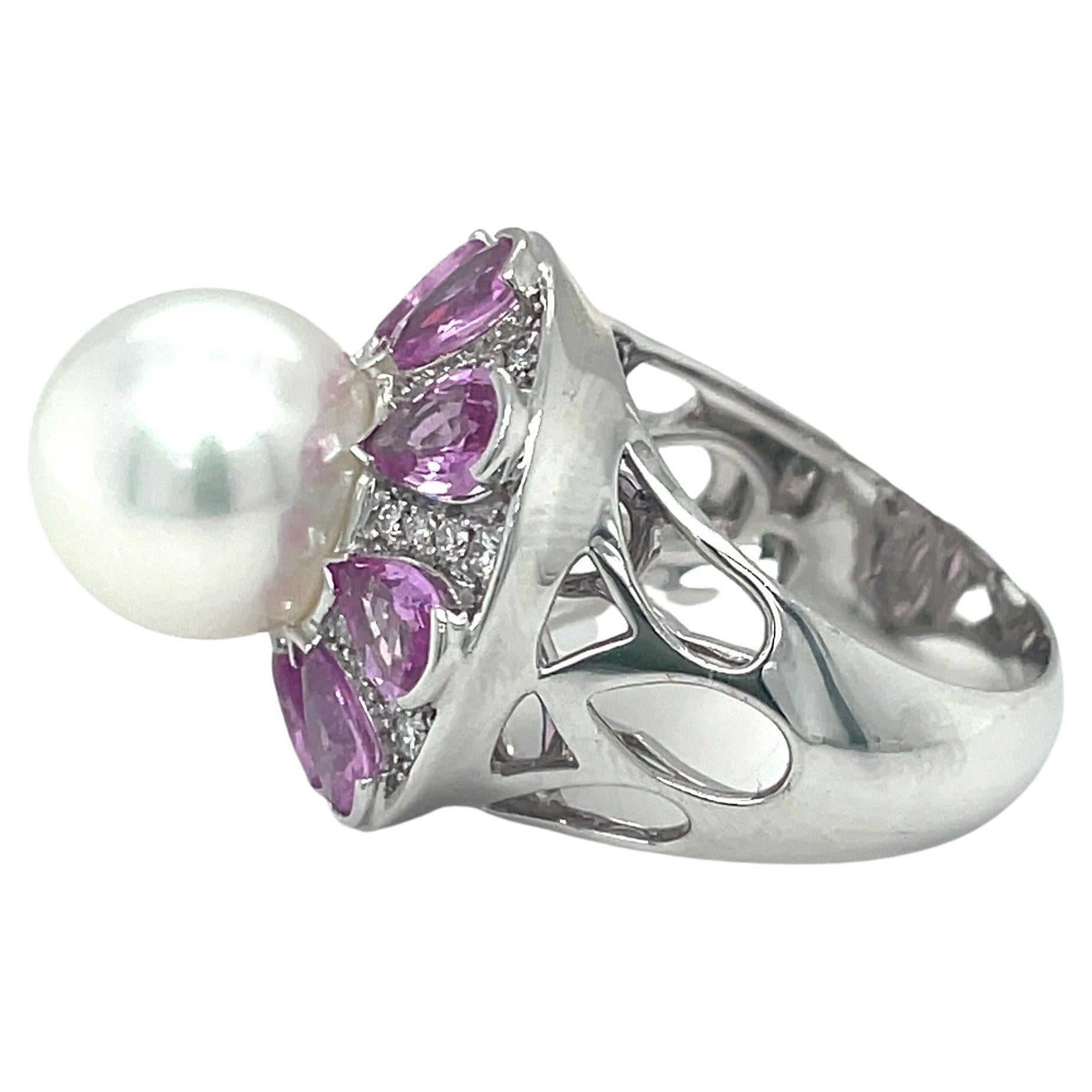 AAA grade cultured South Sea Pearl, round rose pink on silver white in color with a high cluster. Mounted in 18ct white gold and surrounded by pink pear shape sapphires and diamonds. 

Pearl - 11mm near round 
8 pear shaped sapphires = 3.50ct
64