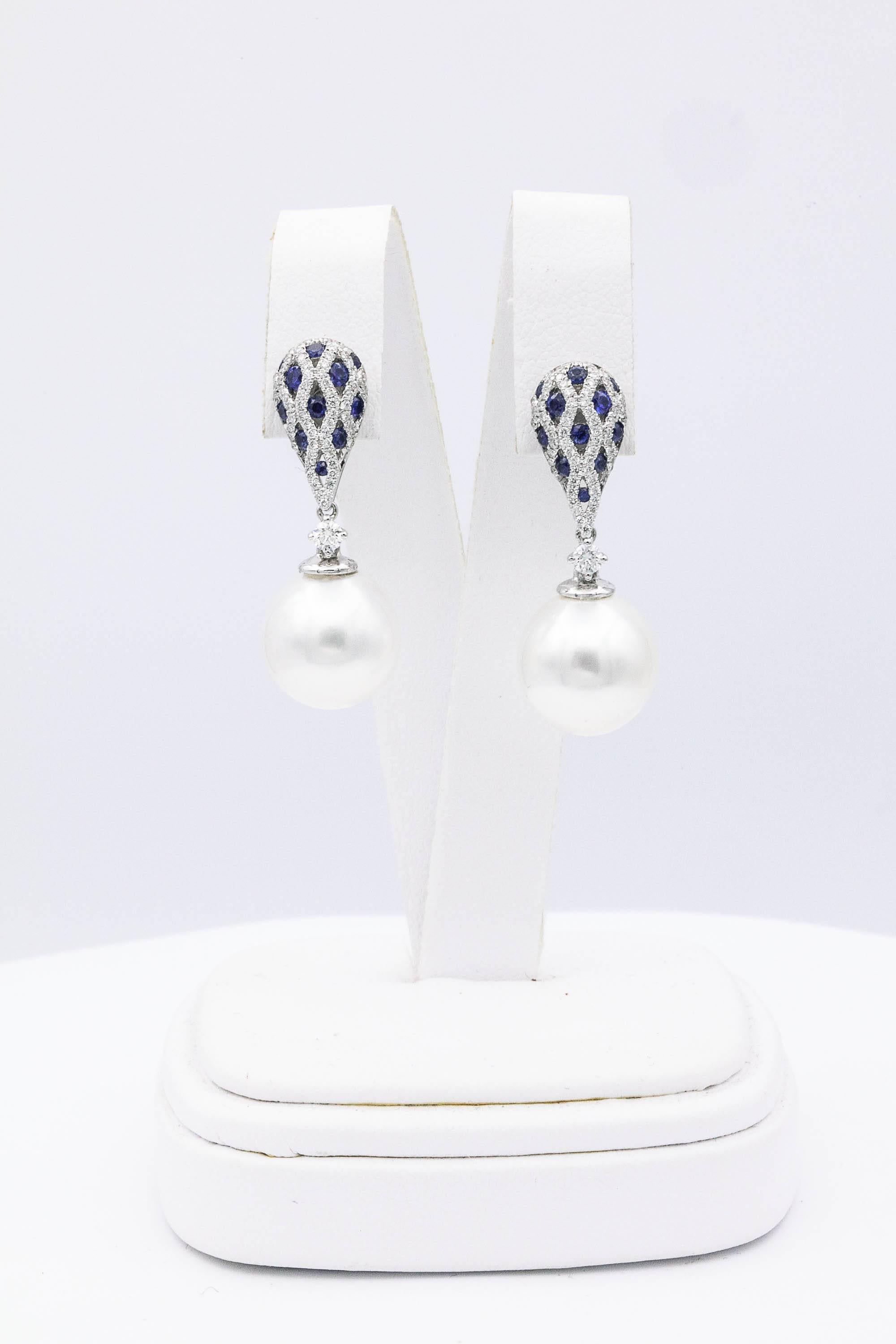 18K White gold earrings featuring two South Sea Pearls measuring 12-13 mm with diamonds, 0.60 carats and sapphires 0.68 carats. Color H-I Clarity SI