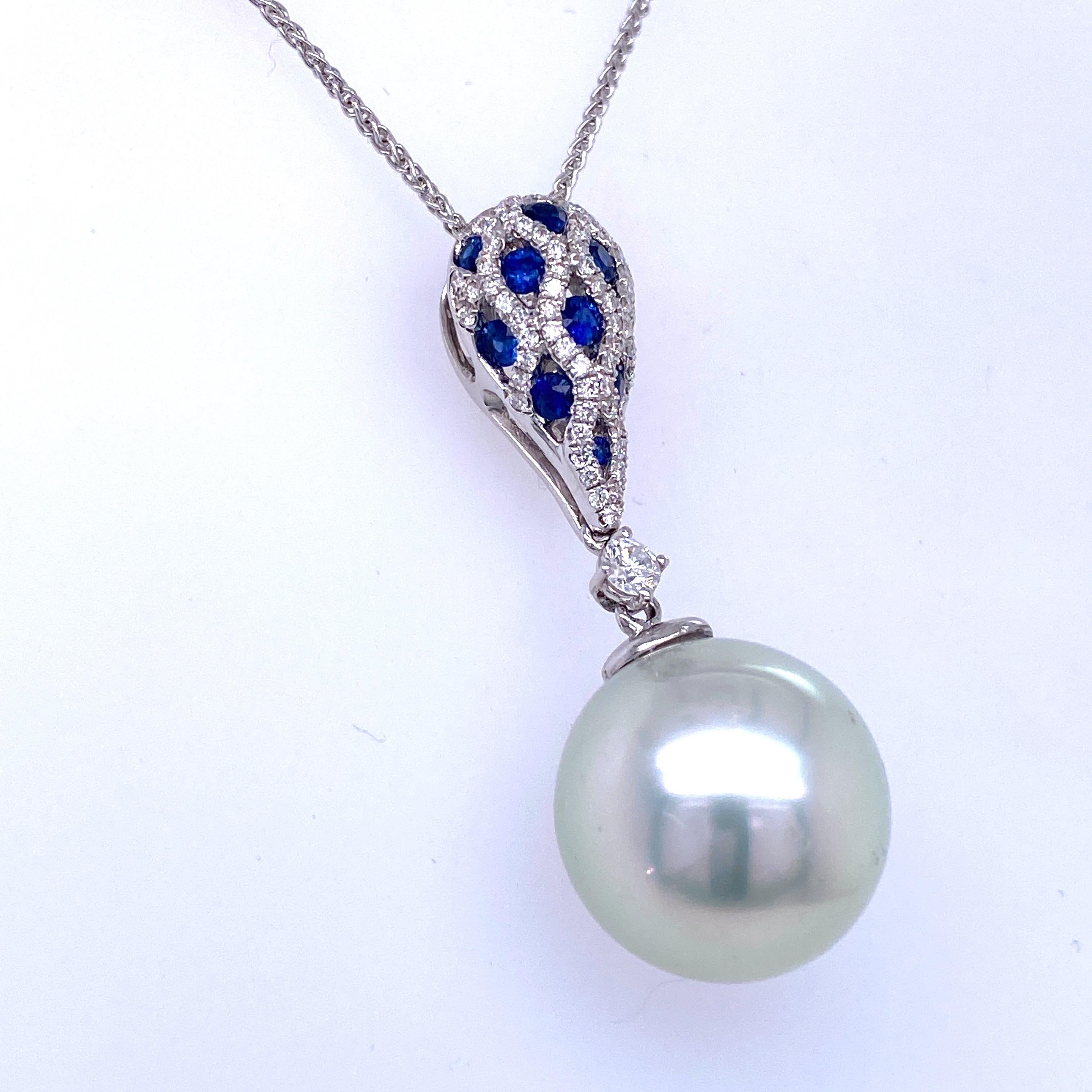 18K White gold pendant necklace featuring one South Sea Pearl measuring 13-14 mm flanked with sapphires weighing 0.34 carats and diamonds weighing 0.30 carats. 