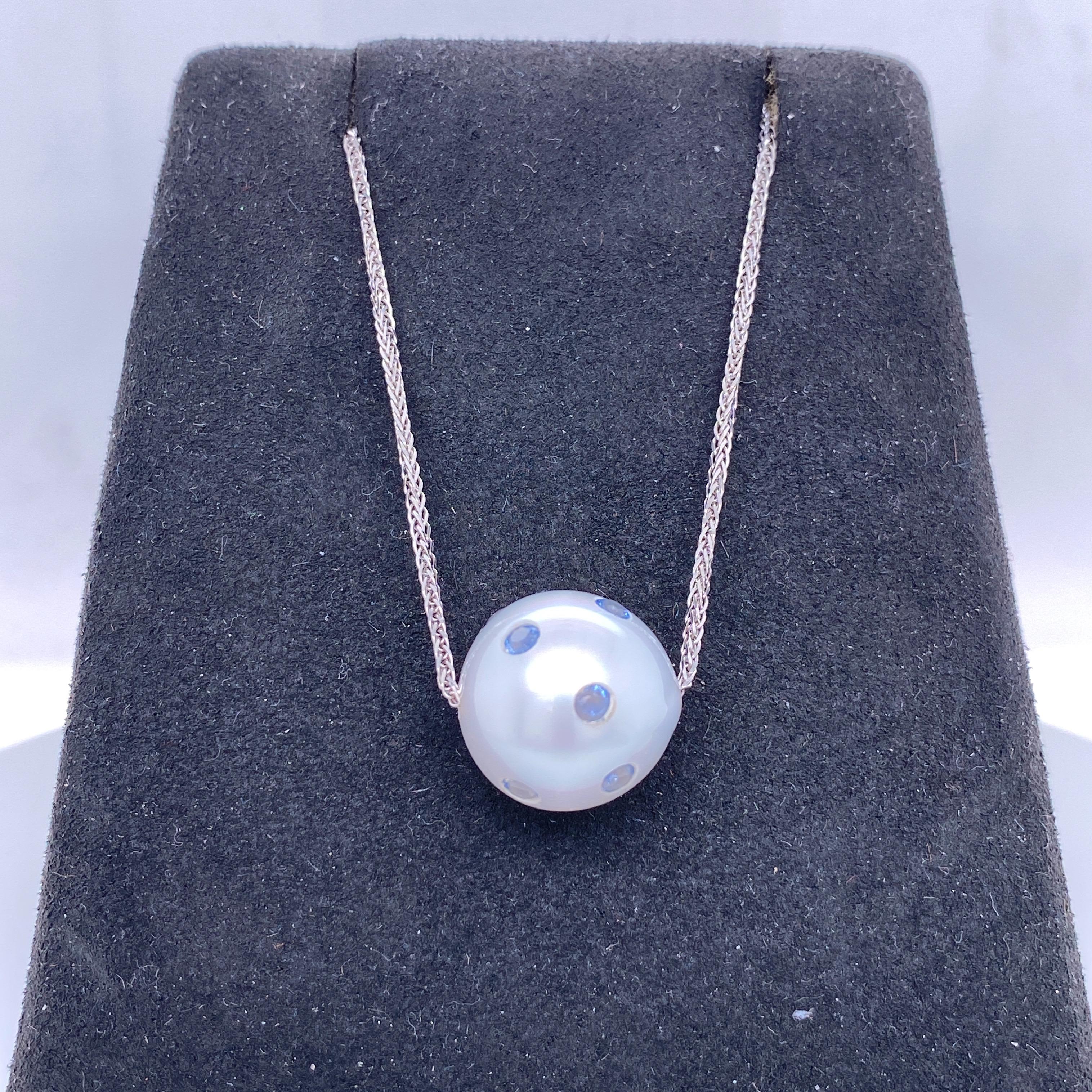 18K White gold slide necklace featuring one South Sea Pearl measuring 14-15 mm with scattered blue sapphires weighing 0.60 carats.