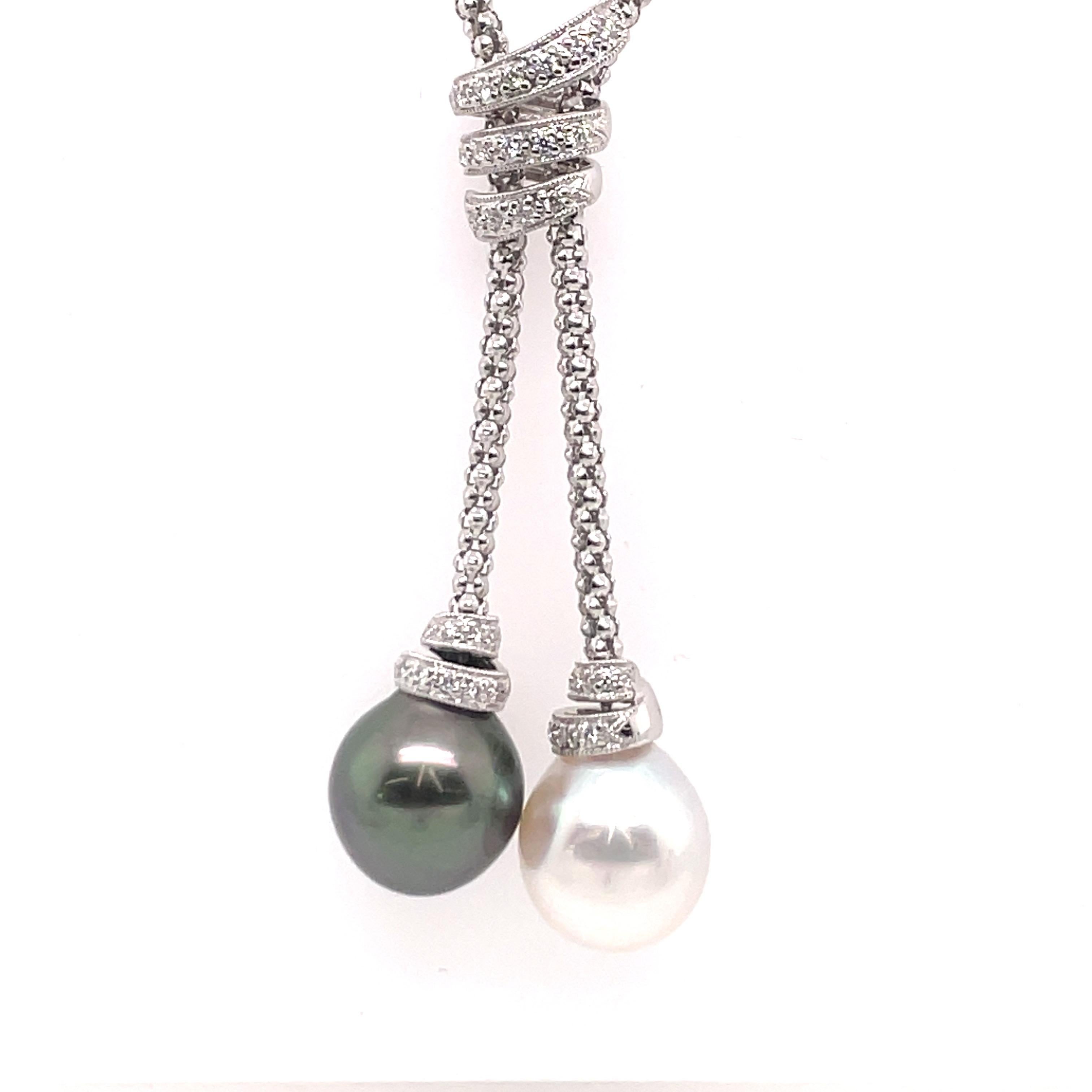 18 Karat White gold chain featuring two Pearls, one South Sea & one Tahitian measuring 12-13 MM with 31 round brilliants weighing 0.31 carats. 
18 inch chain
Tassel 5/8 X 13/16

