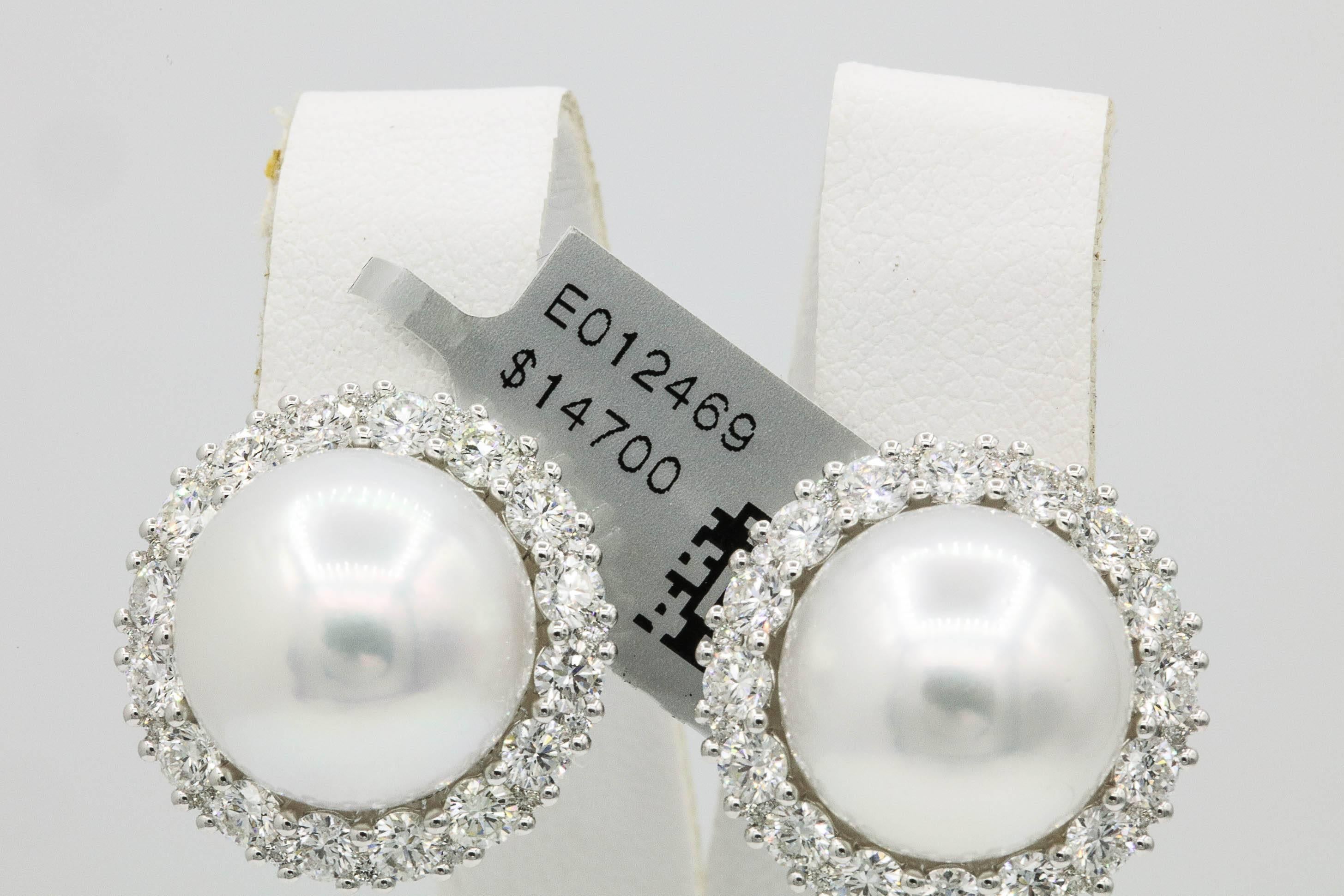 18K White gold earrings featuring two South Sea Pearls measuring 13-14 mm flanked with a diamond halo weighing 2.75 carats. Color G-H Clarity SI