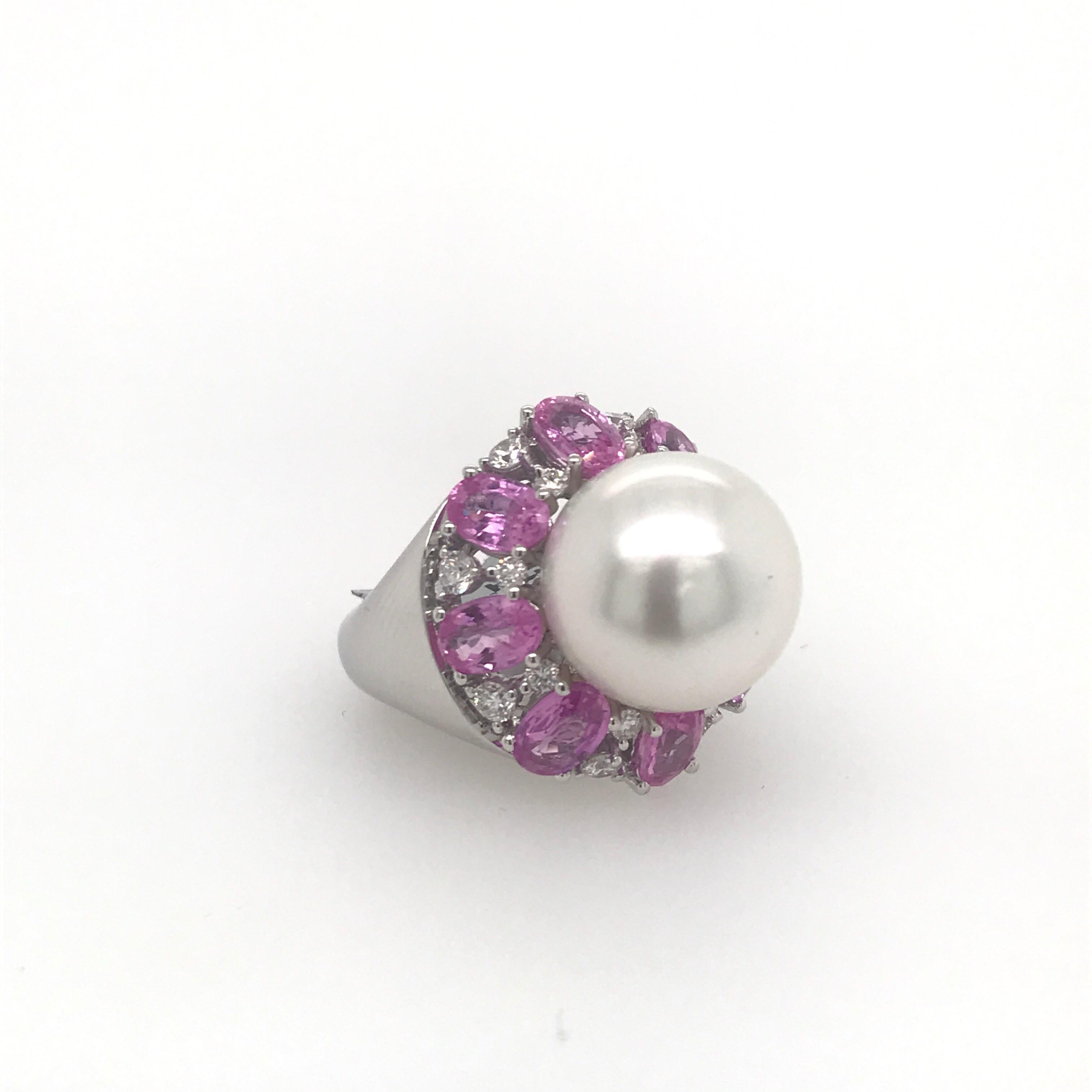 18K White Gold ring featuring one white South Sea pearl measuring 13-14 mm flanked with pink sapphires weighing 4.50 carats and diamonds. 