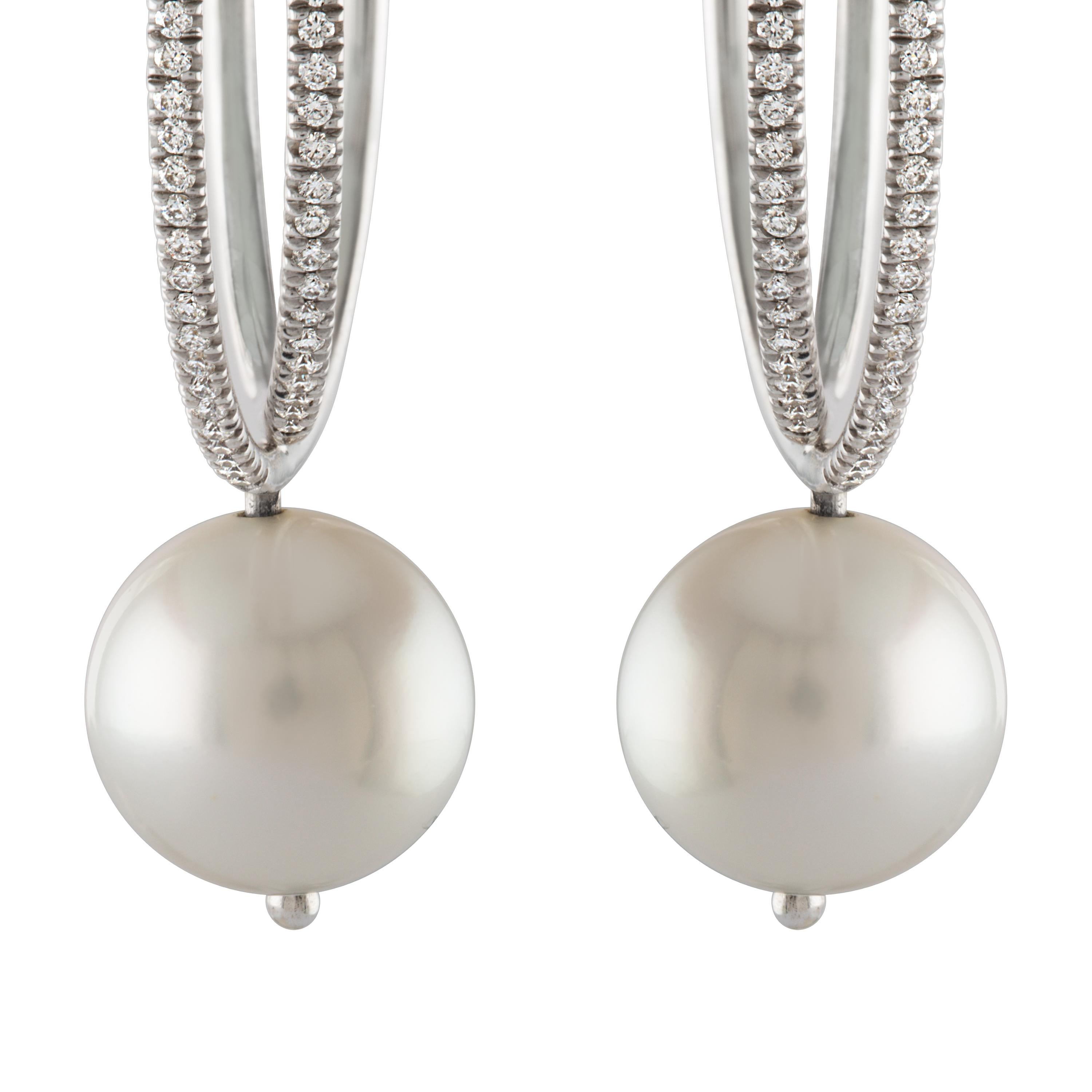 These earrings consist of South Sea white round cultured pearls hanging from 14 karat white gold diamond double hoops. 
The pearls measure 11.4mm and the interlocking hoops have 0.62 carats of diamonds total.
The pearls have superb luster and very