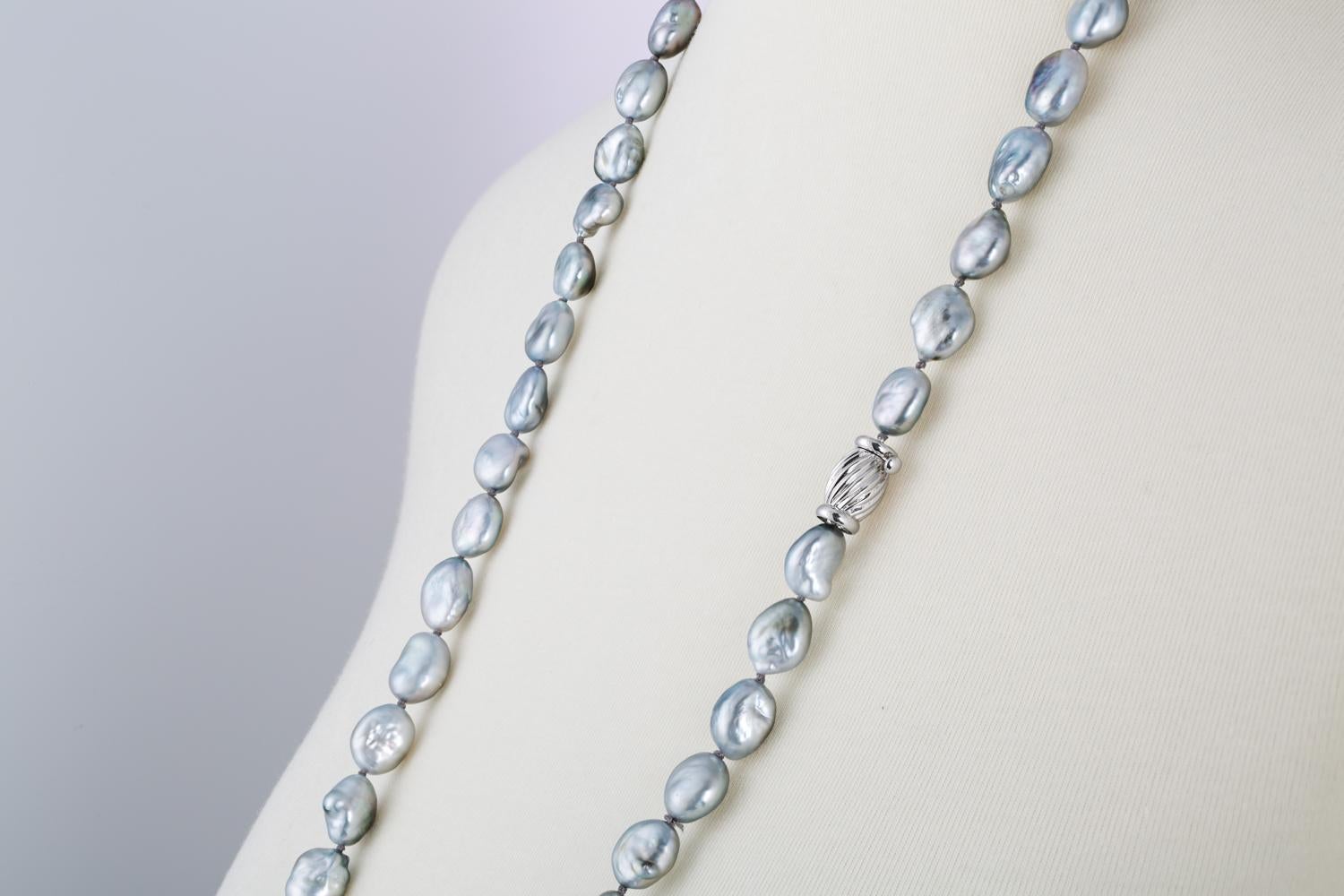 This double-length necklace features baroque shaped South Sea Tahitian cultured pearls measuring 10x11mm. 
The pearls are strung with knots on a 14 karat white barrel clasp. 
The organic shapes of these lustrous pearls are expertly matched.
Their