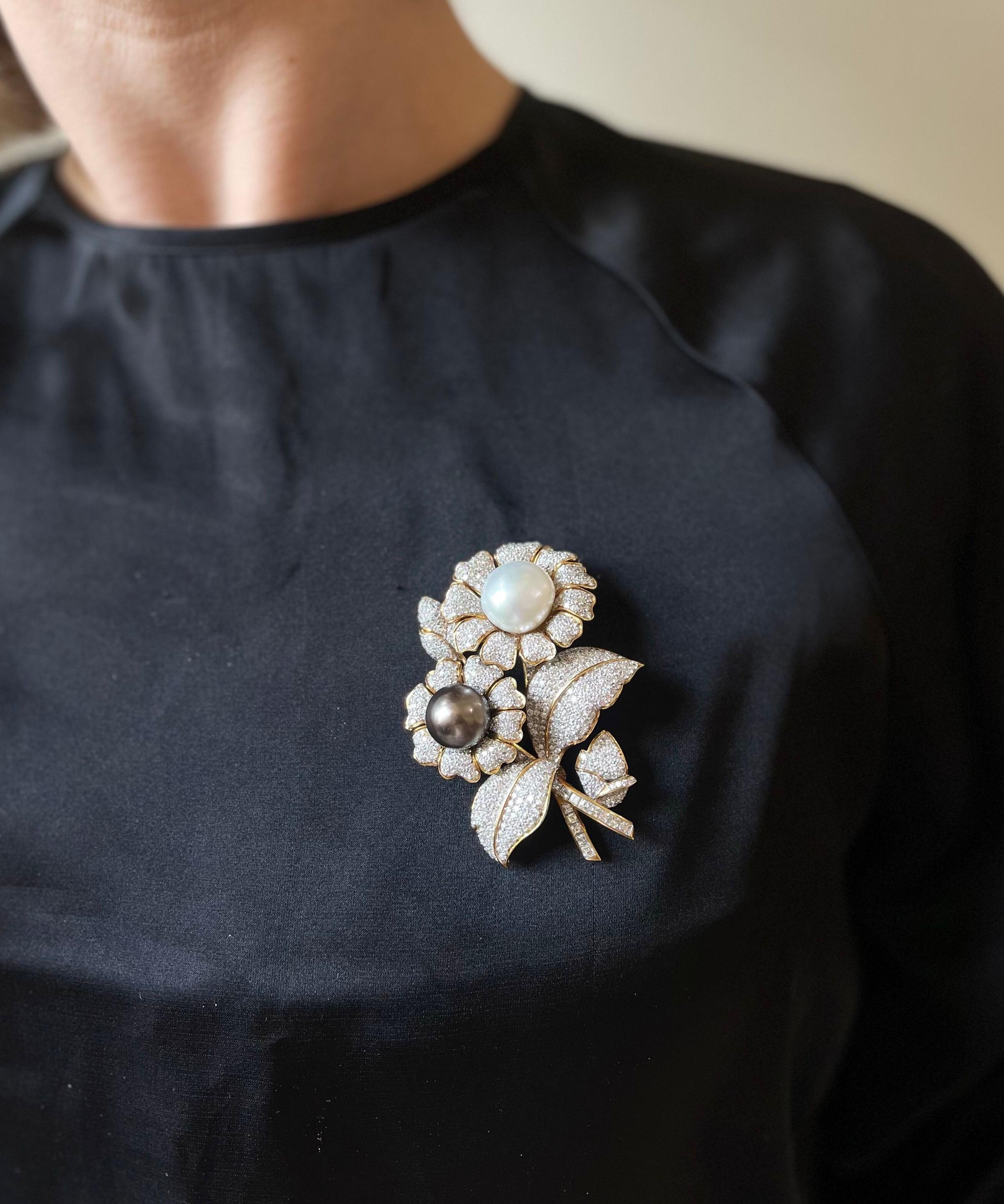 Large 18k gold brooch, depicting two sunflowers, set with a 14.1mm South Sea Tahitian and 16.1mm white South Sea pearl, surrounded with a total of approx. 8-9 carats in SI/H-I diamonds. Brooch measures 2.75
