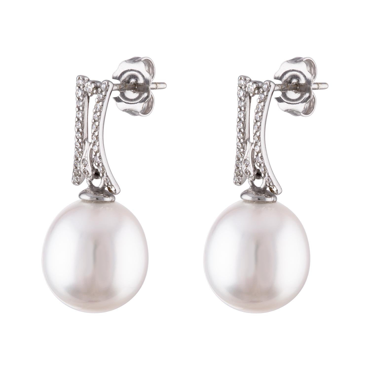 These dangle earrings feature South Sea white cultured drop pearls measuring 11.3x12.2mm set on 18 karat white gold and diamond findings. The earrings consist of 0.24 carats total of diamonds. The earrings are fitted with secure push friction backs.