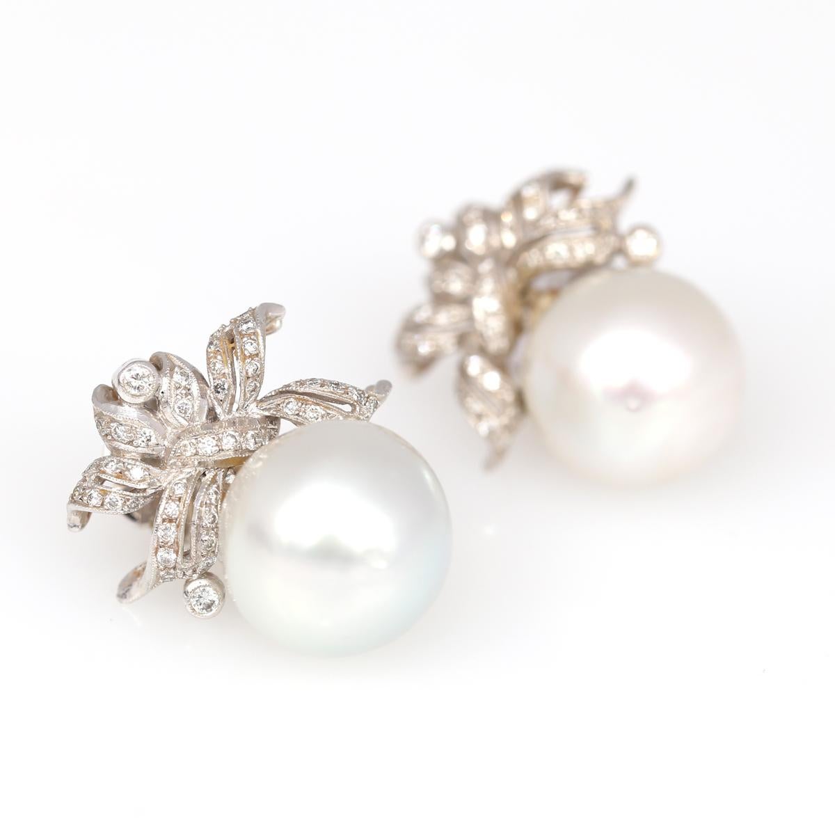 Fine 15mm South Sea White Pearls and Diamonds Earrings. Delicate and very stylish jewelry item. The sophisticated ribbon set with fine Diamonds is holding a fine 15mm round white pearl. The pearl is not fixed tightly so it moves a little bit with