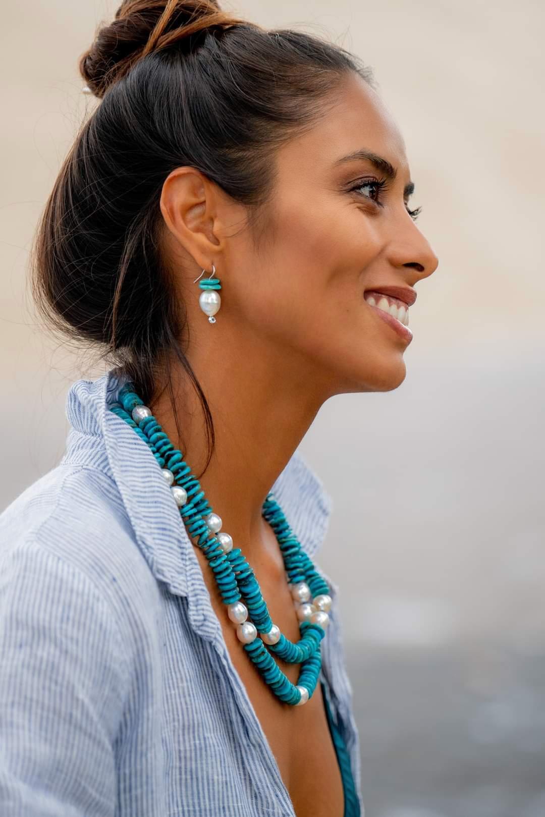 Oblong, drop shape South Sea White Pearls, approximately 12mm x 14mm, are accentuated by bright blue Natural Turquoise slivers. Rhodium plated Sterling Silver wire hooks with Cubic Zirconia bezel set accents at the bottom to finish this simple but