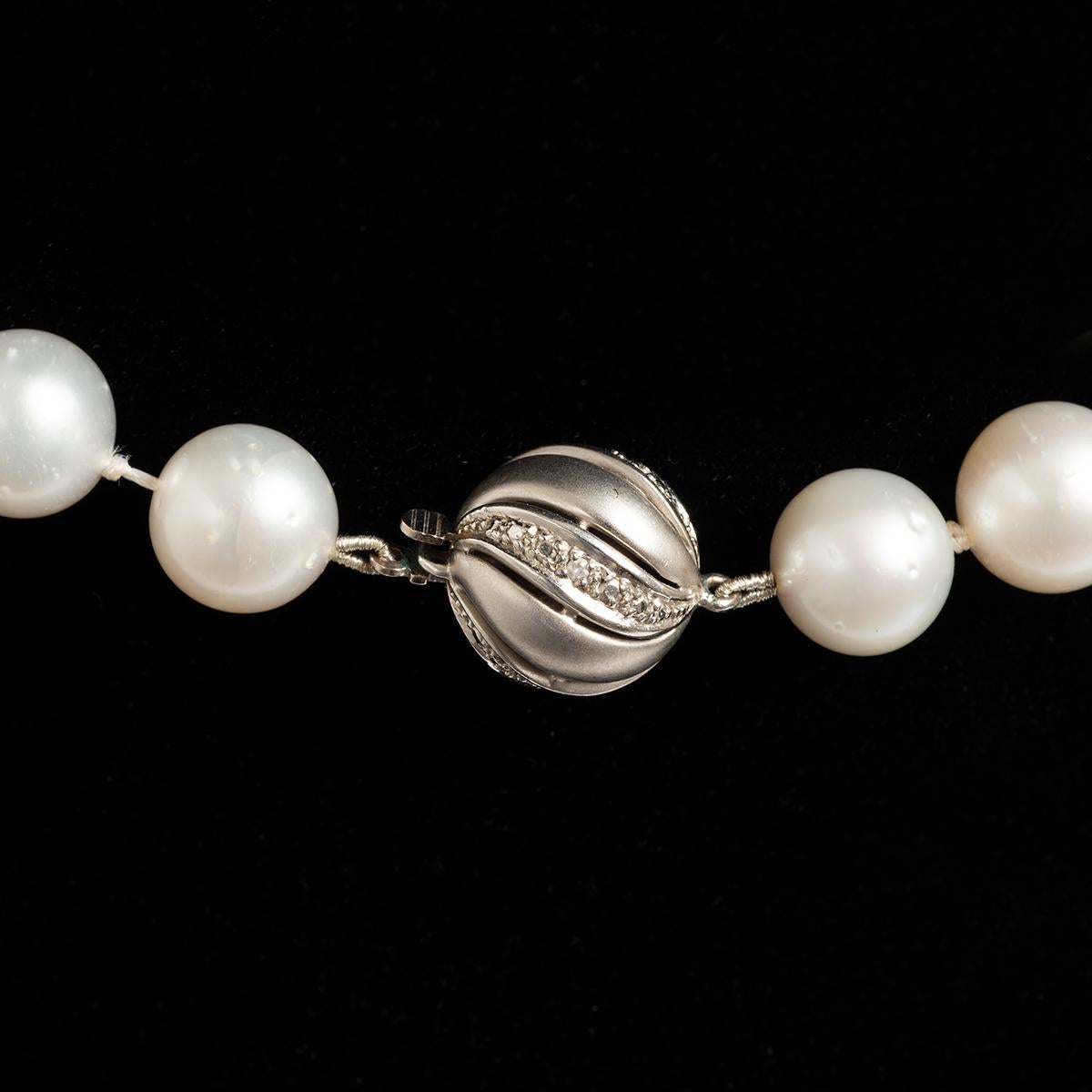 Our contemporary, circa 2000, exceptional quality pearl necklace consists of the finest graduated white natural South Sea pearls. Each significant pearl is individually knotted between for security to the chain, and is fastened by a decorative ball