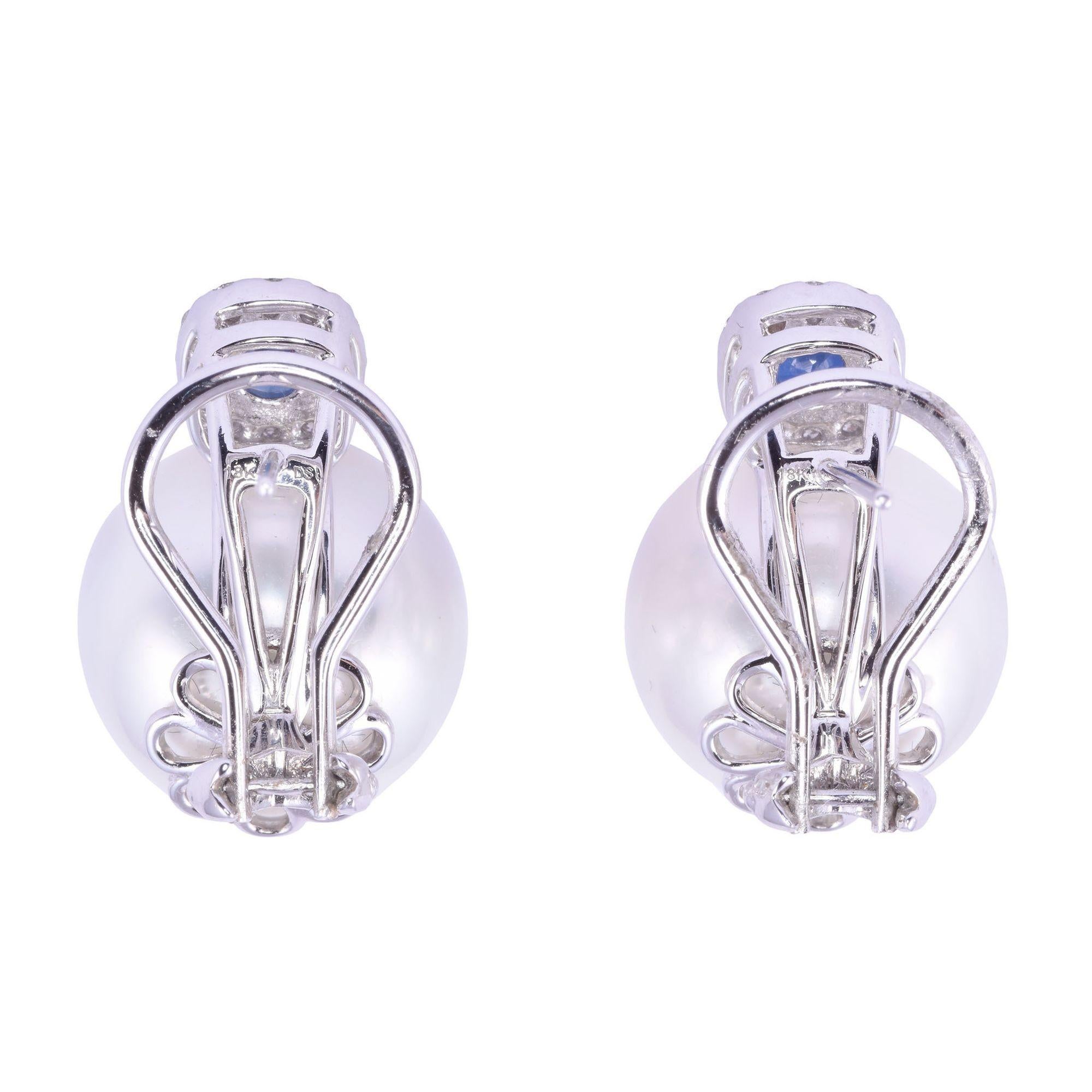 Estate South Seas pearl & sapphire earrings. These 18 karat white gold earrings feature large cultured South Seas pearls at 14.05-14.20mm with fine quality, very good luster, and excellent nacre. The two round sapphires have a carat total weight of