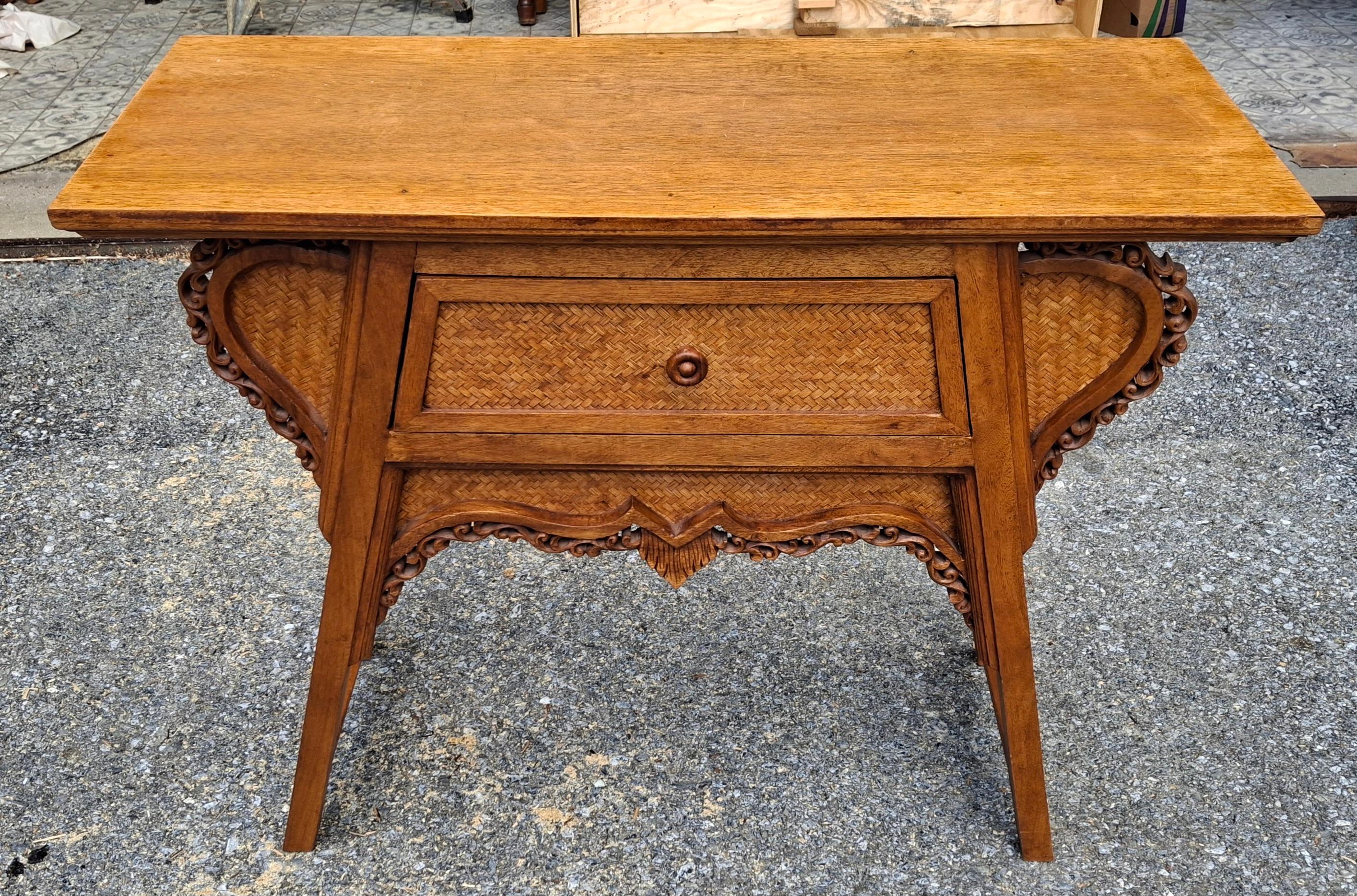 A Southeast Asian Carved Fruitwood Console/ Altar Table with wicker front. 
Measures 35.5