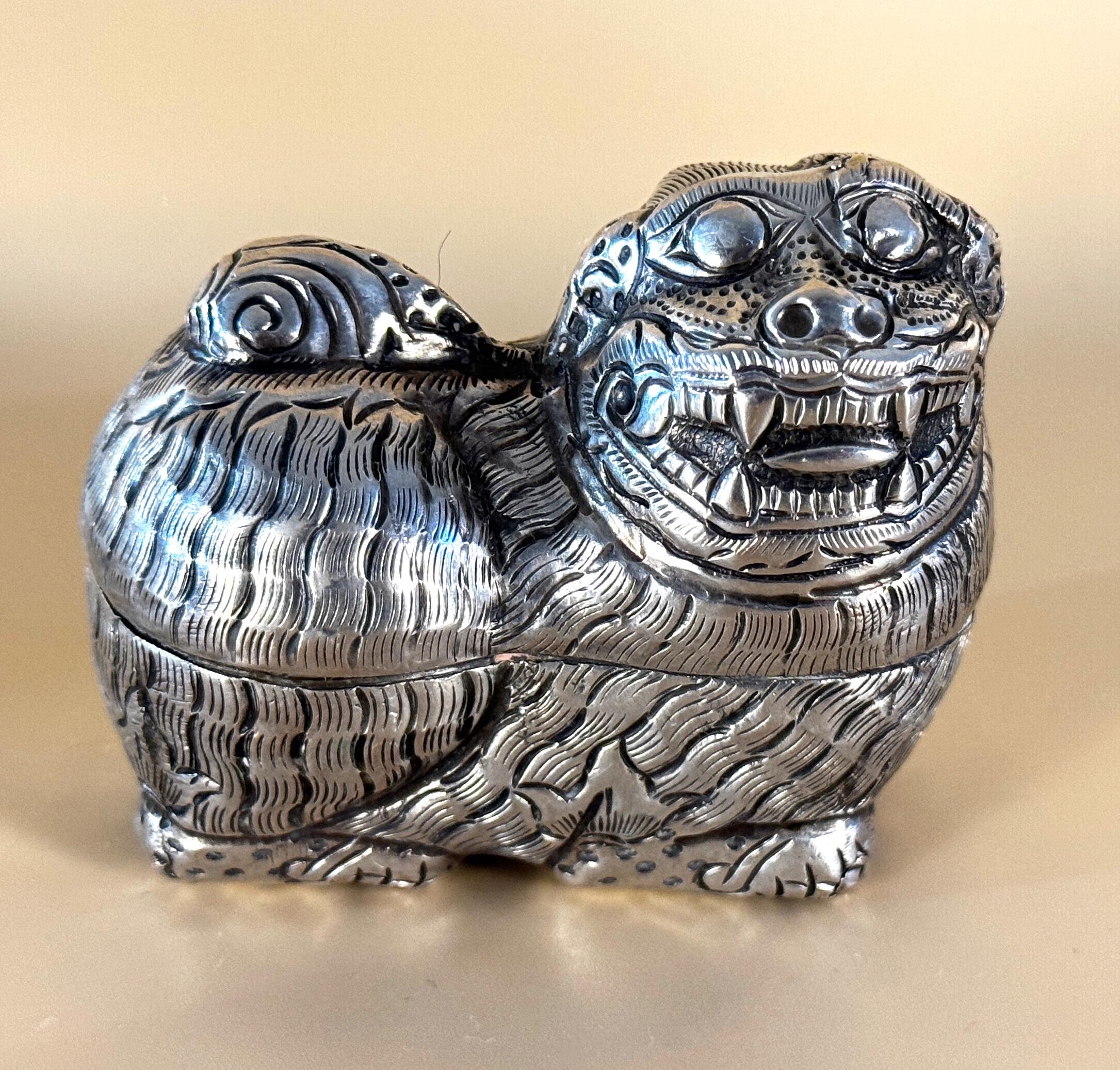 Dos pequeñas cajas decorativas de betel de plata del Sudeste Asiático, una en forma de perro foo o león, la otra decorada en repoussé con bordes de cuentas y follaje. Las cajas tienen una pátina preciosa y muestran muy bien su antigüedad; serían