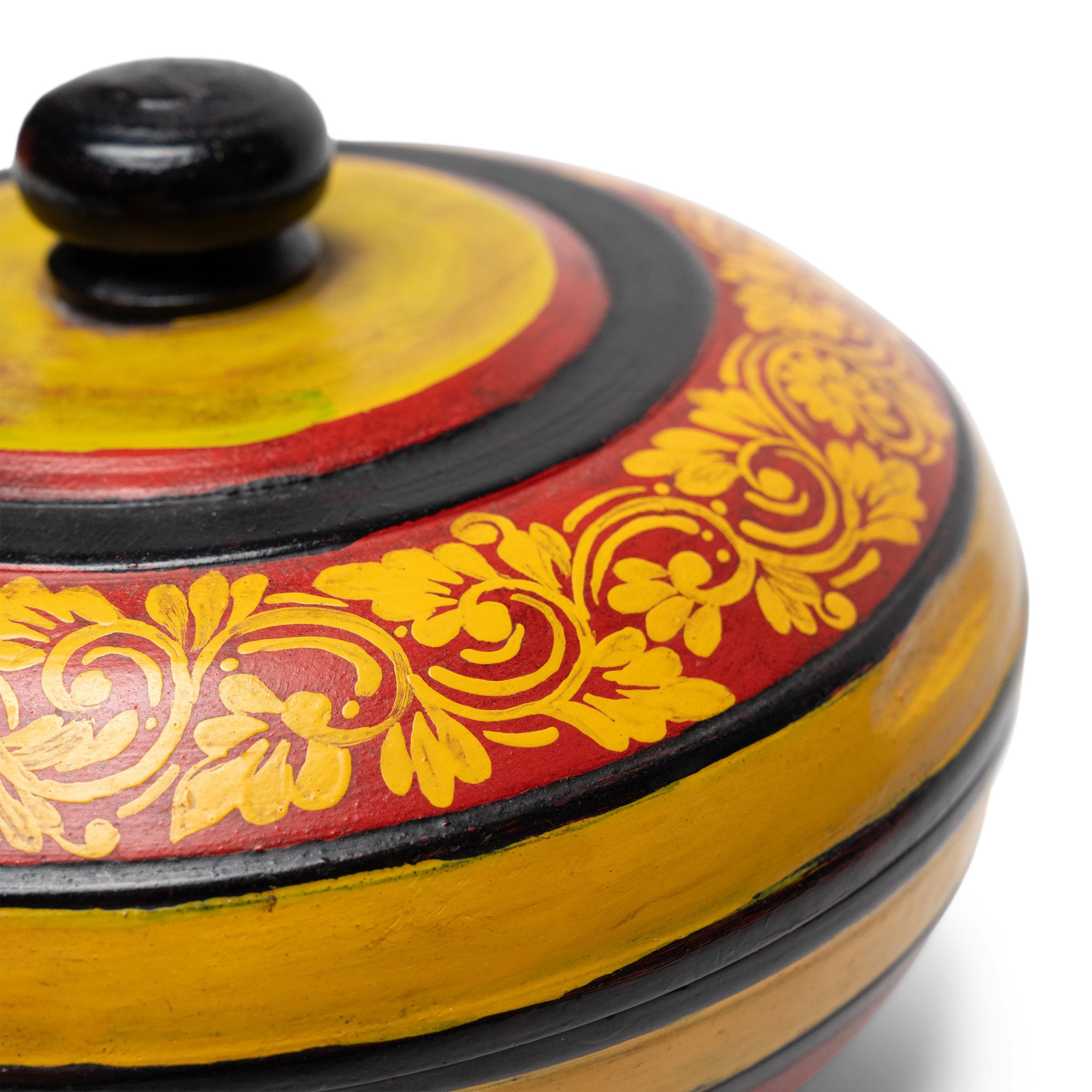 Cette boîte à offrandes sur pied originaire d'Asie du Sud-Est apporte des couleurs vives et un charme folklorique aux intérieurs modernes en tant que vide-poche ou plat universel. La boîte vintage est façonnée en bois tourné à la main et décorée de