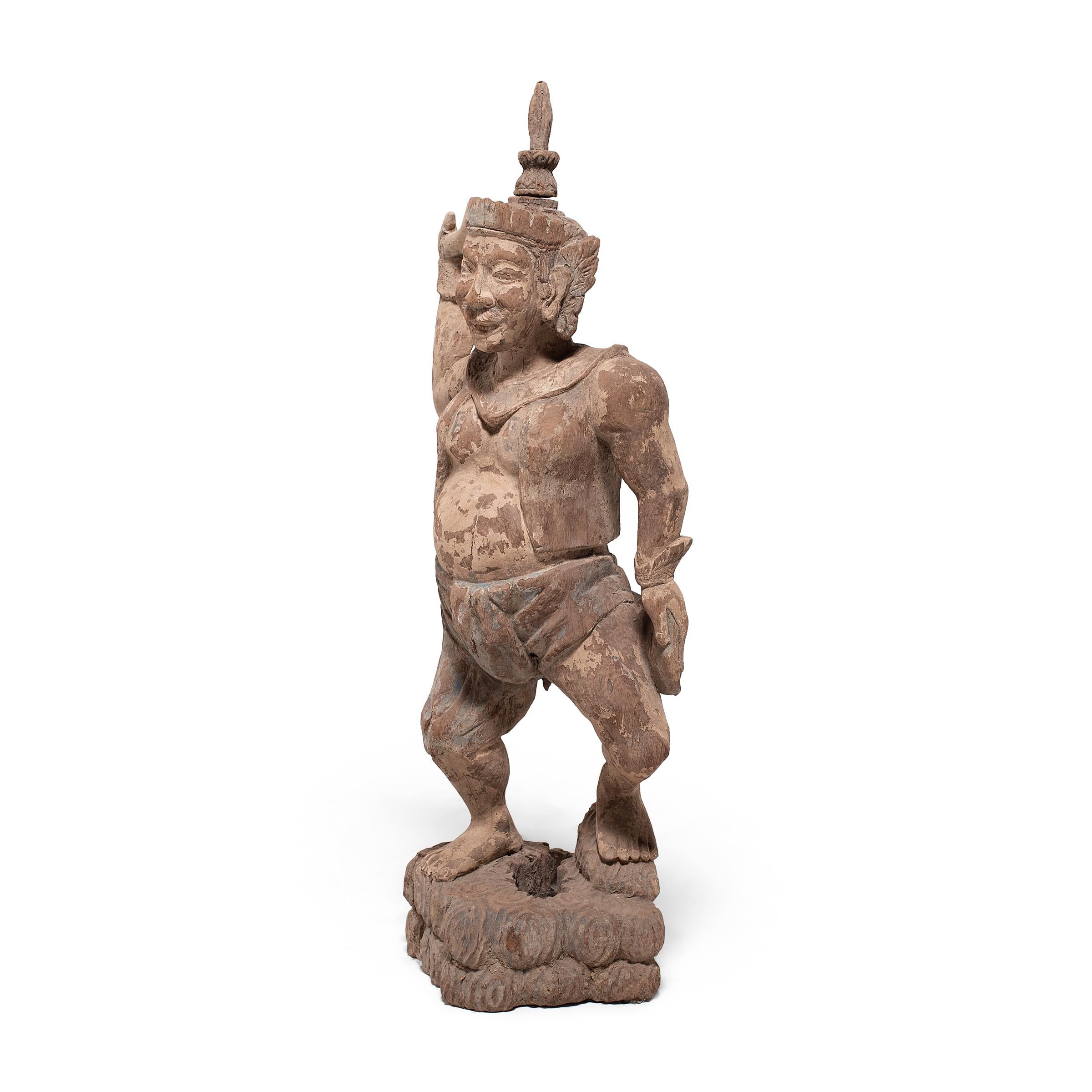 This large polychromed wood figure from southeast Asia dates to the mid-19th century and depicts a male attendant or entertainer. Hand-carved by a skilled artisan, the wooden figure is dressed in a vest and cloth pants and wears a traditional