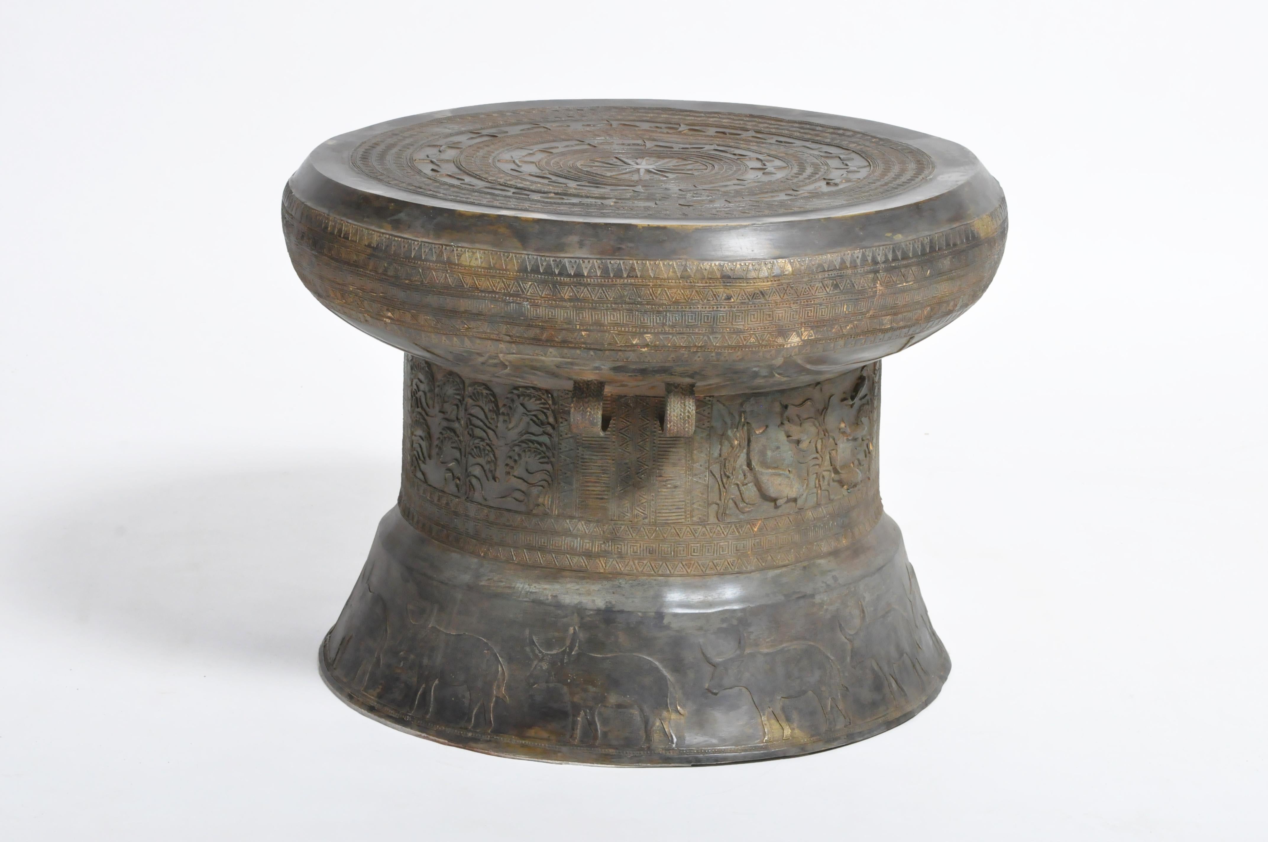 This handsomely patinated drum has a circular top and has been decorated with radiating bands and geometric patterns throughout, the waisted body is flanked by handles while the bases feature ox figures along the base. Based on 2000-year-old forms,