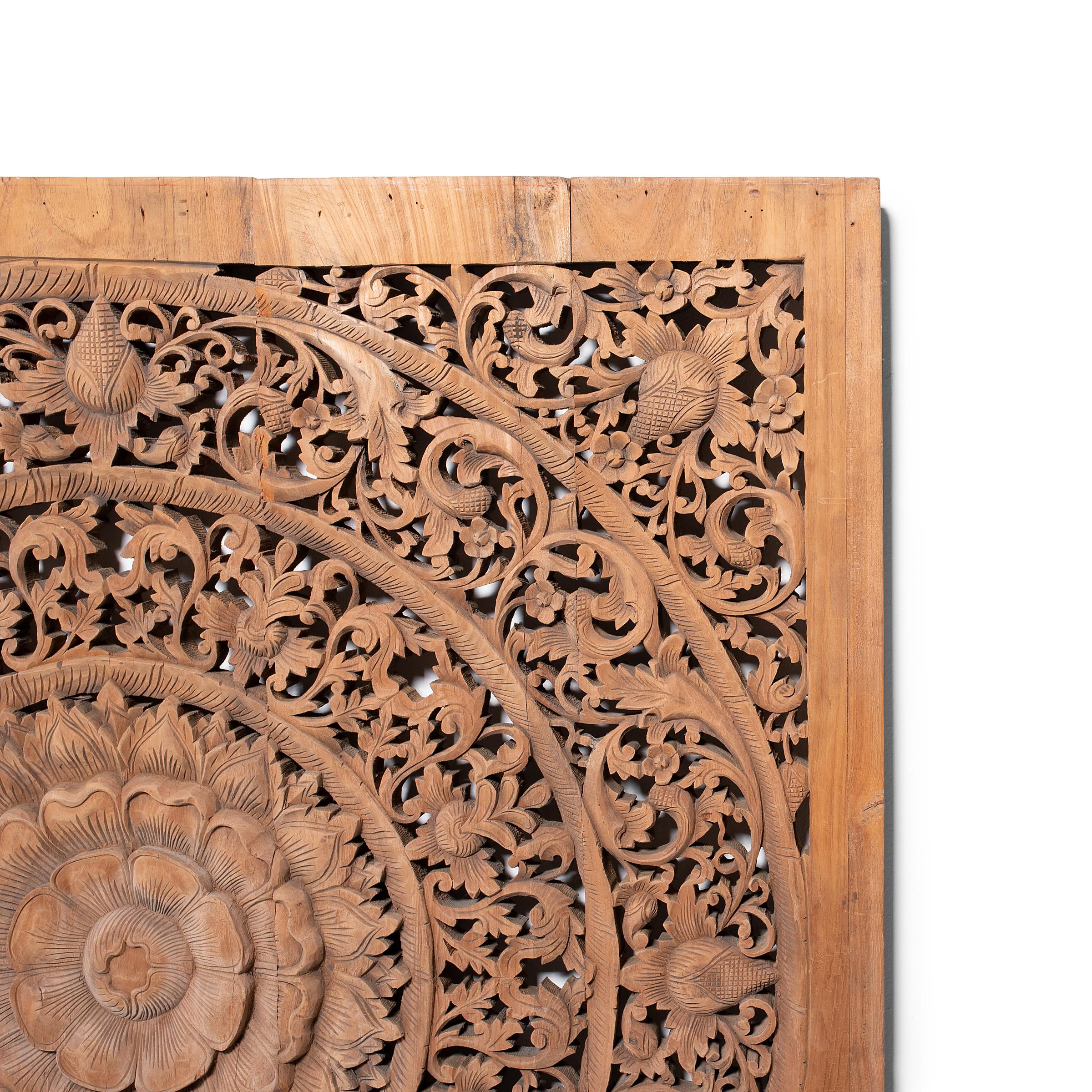 Worked from reclaimed teak boards, this large, five-board panel is hand-carved with a decorative pierced mandala design in the style of Thai or Balinese fretwork screens. Concentric circles of foliate scrollwork radiate from a central lotus blossom,