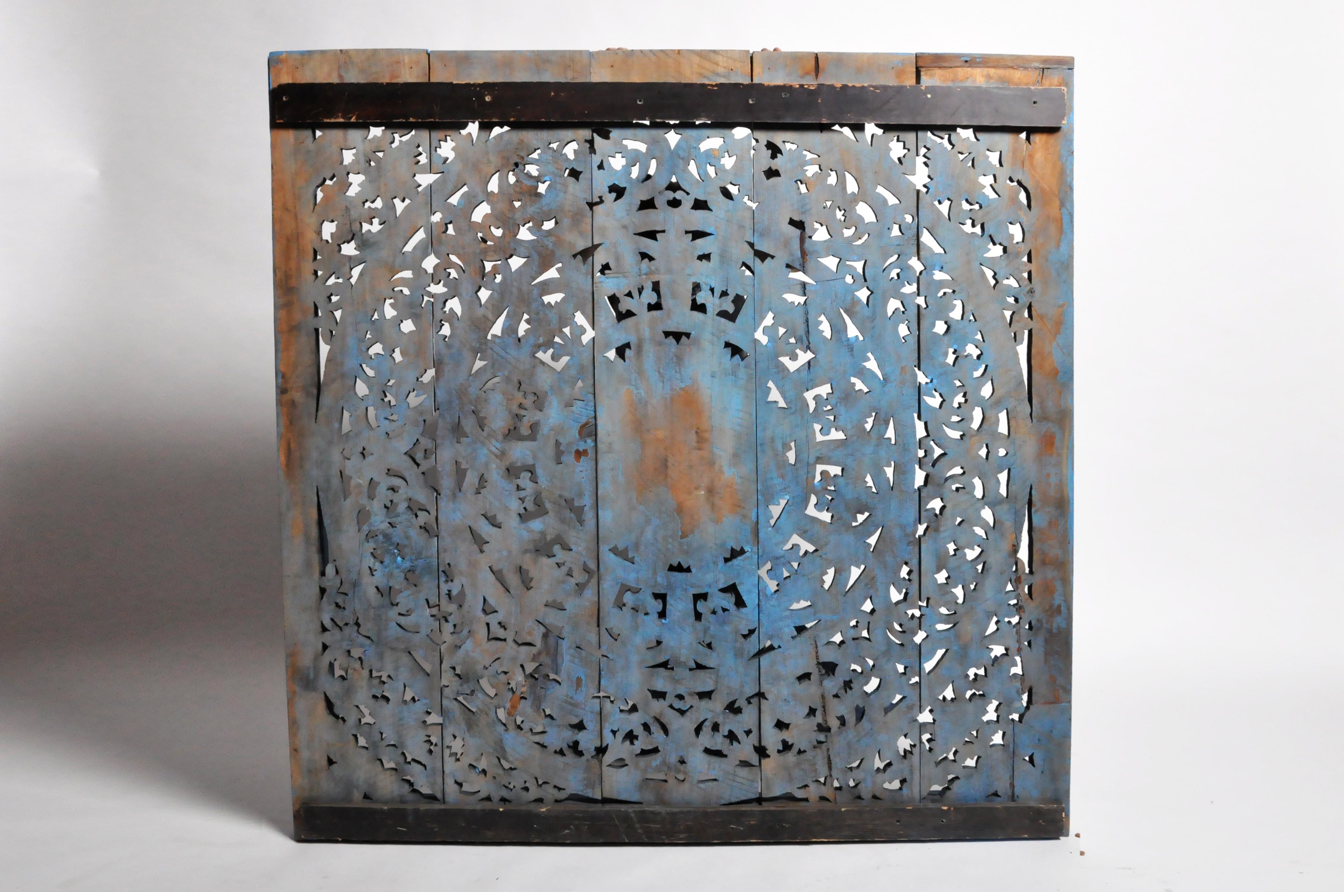 The hand carved relief features a central lotus flower medallion, encompassed by scrolling foliage and budding vine decoration. Intricately carved from teak wood, the piece has been painted with a “Krishna” blue wash traditional to much of India.