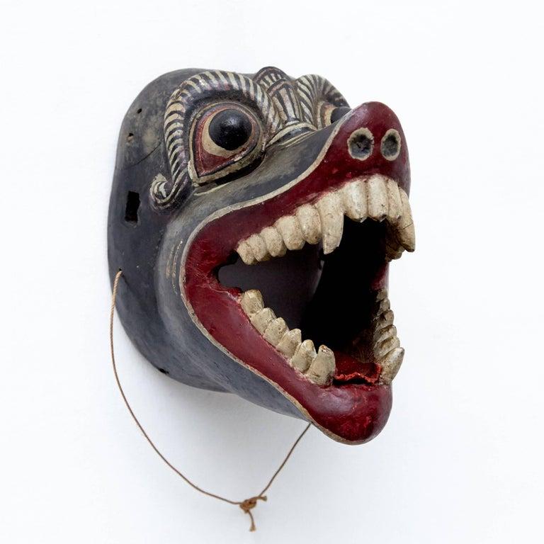Traditional mask from Southeast of Asia, circa 20th century.

Craved wood and painted by hand.

In good condition with wear consistent with age and use, preserving a beautiful patina with some scratches and hits., missing a piece of the leather