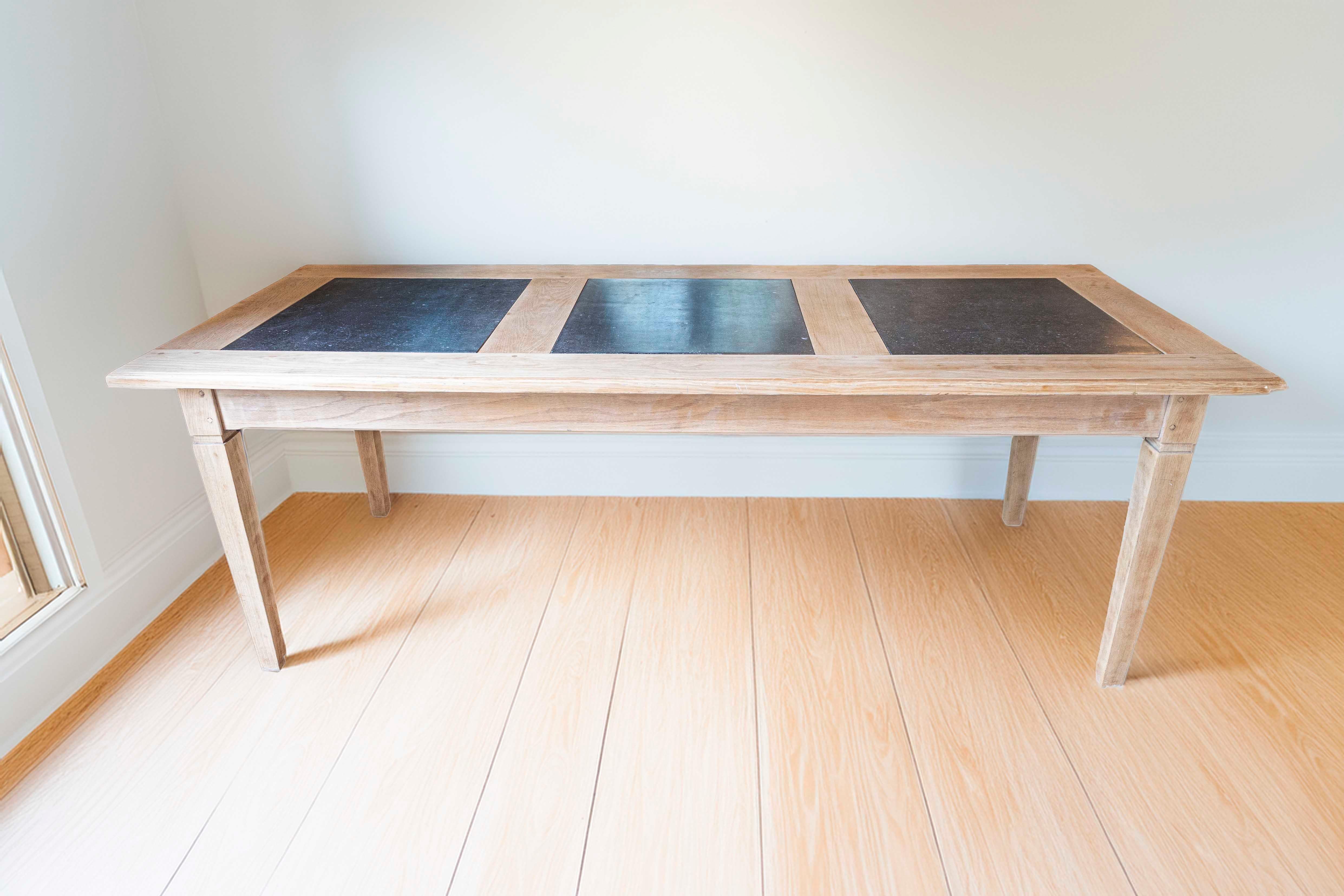 Table de salle à manger en chêne naturel du milieu du siècle dernier, avec plateau en marbre fossile noir et pieds fuselés. Cette table de salle à manger Midcentury du sud de la France, avec son charme rustique et son élégance discrète, se compose