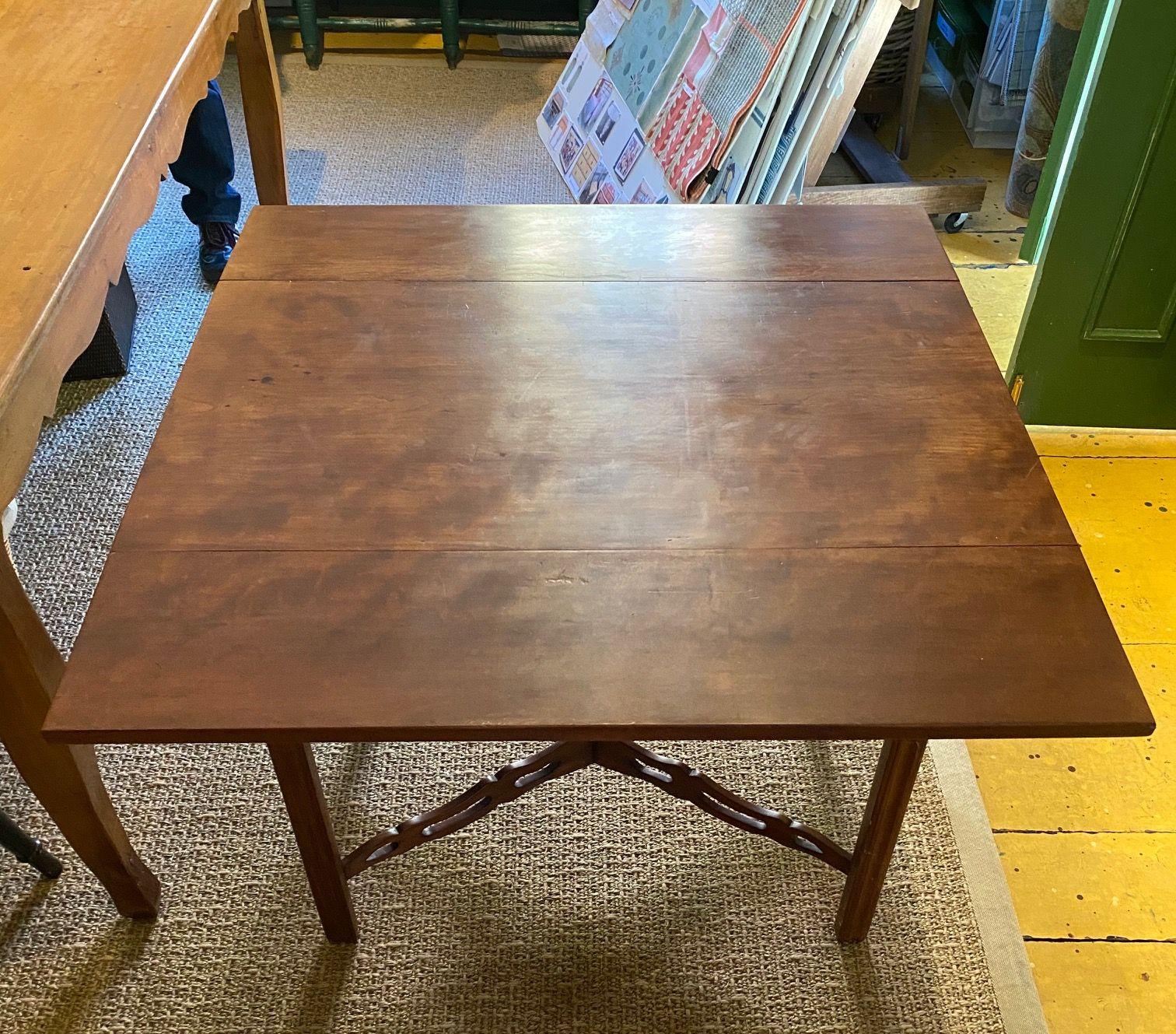 Southern New England Chippendale cherry drop-leaf table, probably from Connecticut, circa 1770, having a rectangular top with mid length drop leaves, raised on square chamfered legs braced by carved and pierced X-stretchers. The table remains in