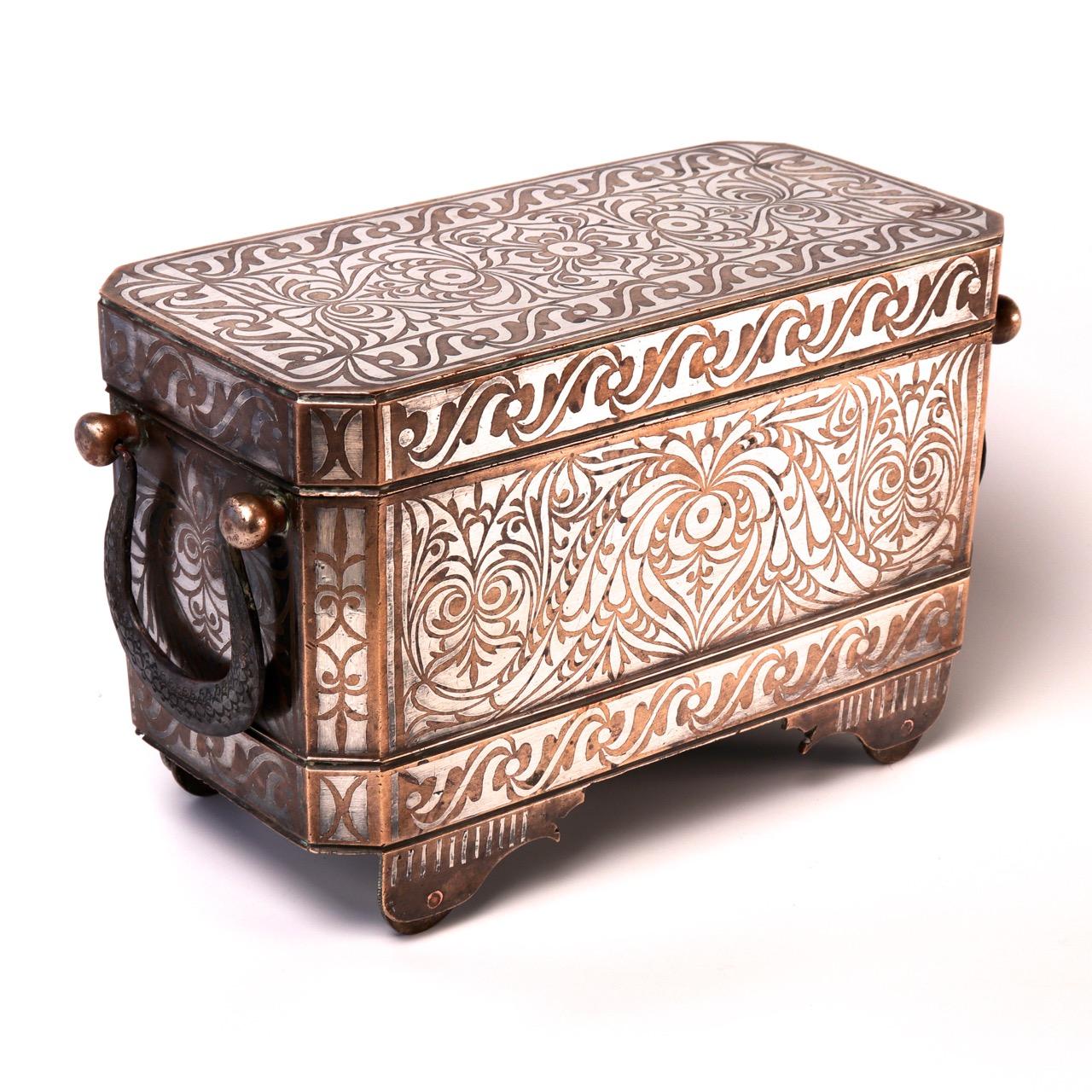 Southern Philippine (Mindanao) brass with silver inlay betel box, a large and heavy size with wheels, the rectangular body with hinged lid, supported on four wheeled feet, the silver inlay on the sides, chamfered corners and lid are in the tendril