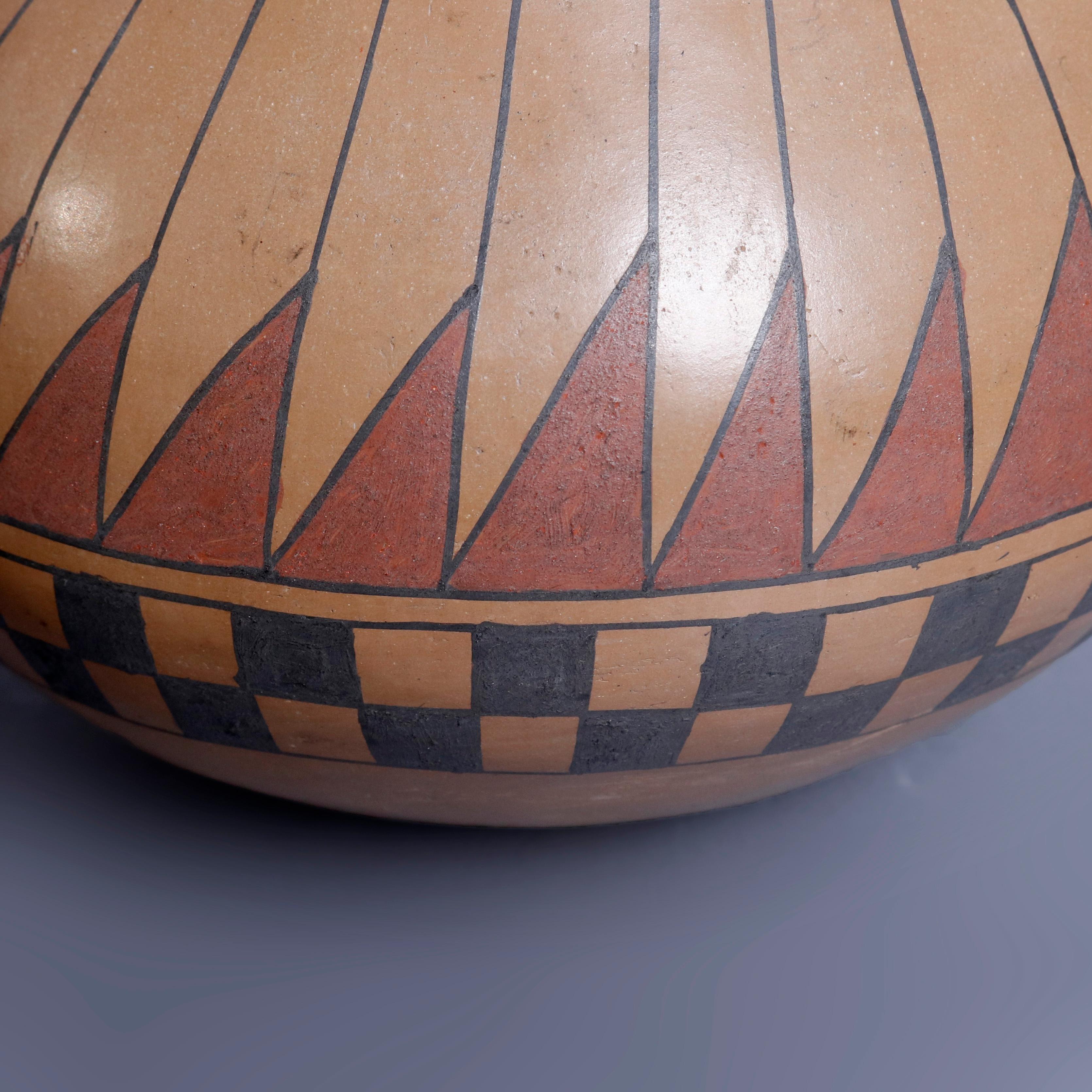 An antique Southwest Native American Indian Acoma style hand thrown pottery vase by Beto Tena offers bulbous form with polychromed repeating stylized feather band over checkerboard band hand painted with yucca brush, artist signed on base, 20th