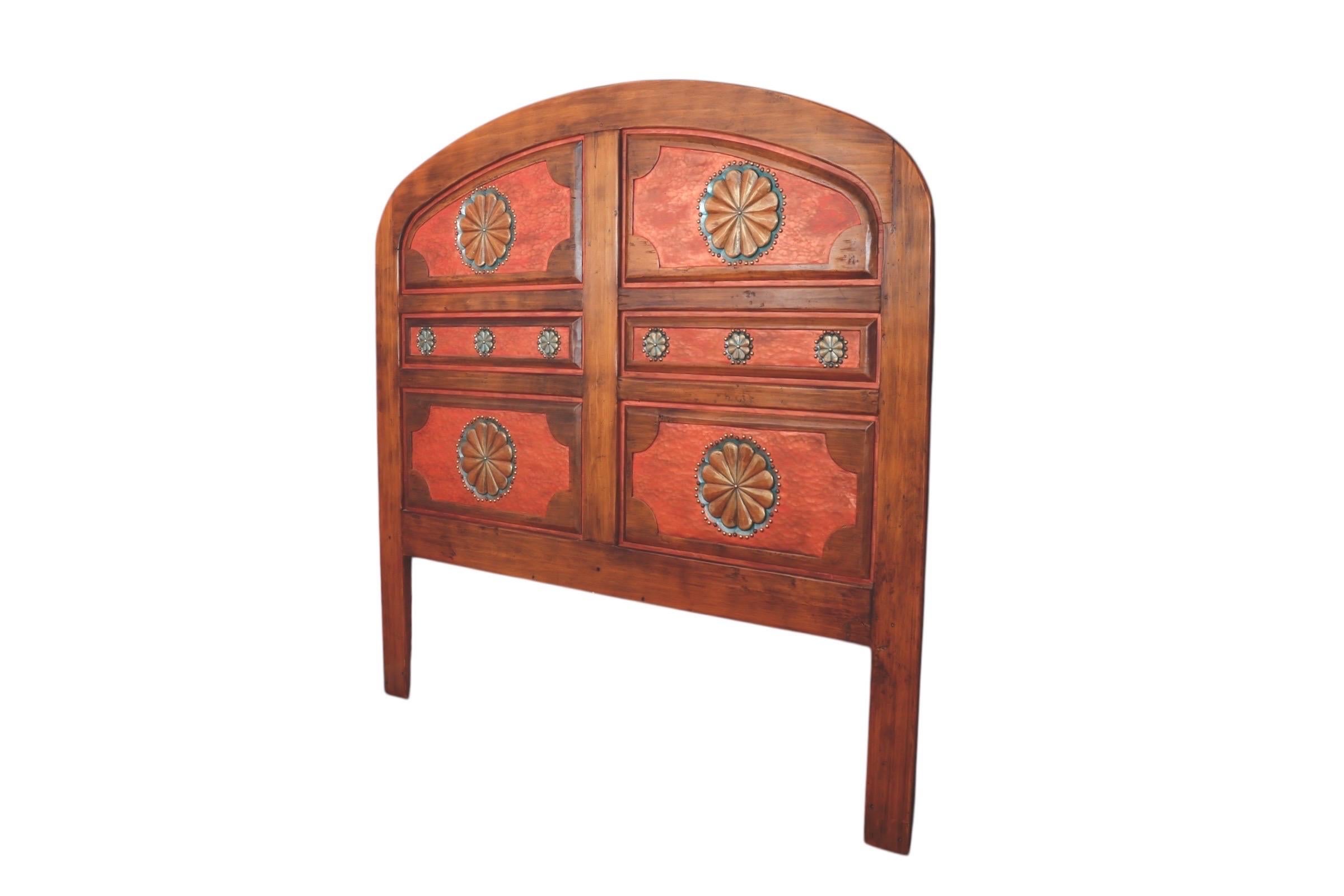 A custom-made Santa Fe style king size headboard made by Southwest Spanish Craftsman Company. Handcrafted from solid alder wood, using 16th-century tools, the headboard is carved with rosettes decorated with nail heads. Maker's mark is carved in the
