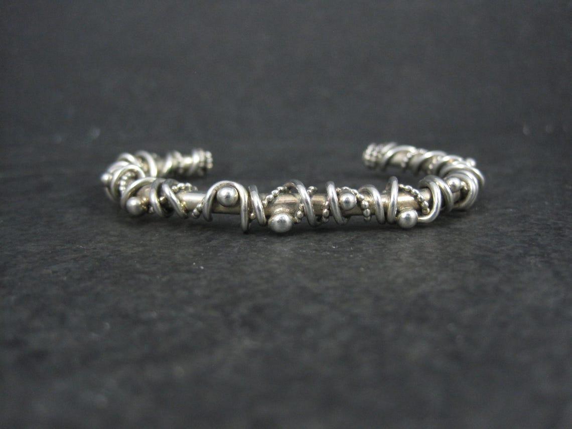 This gorgeous Southwestern cuff bracelet is sterling silver.
It features a brutalist, wire wrapped design.
This bracelet measures 1/4 of an inch wide. It has an inner circumference of 5 1/2 inches including the 1 1/8 inch gap.
Weight: 21.7