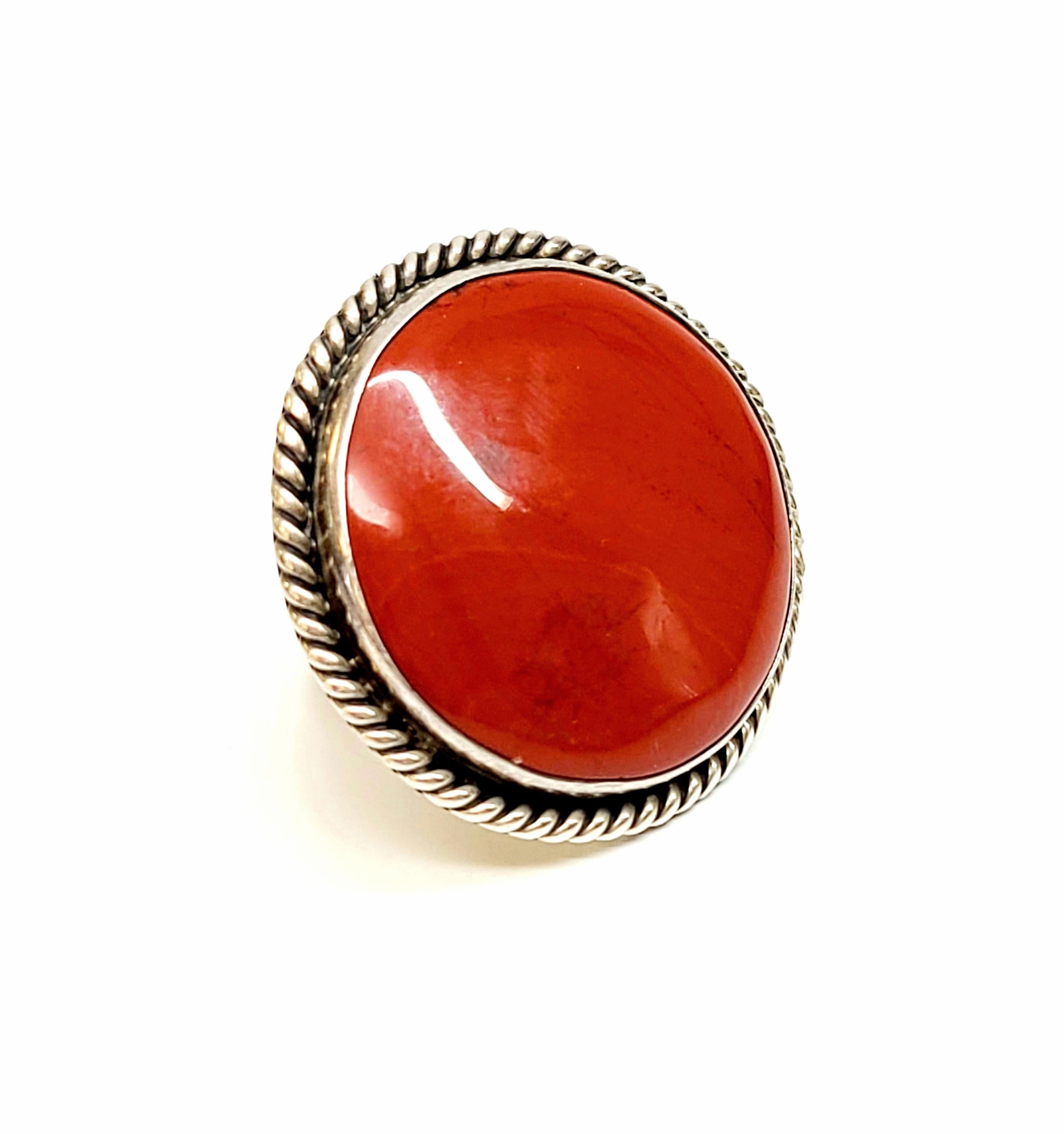 Sterling silver and red jasper ring by  Kenny B. Braken.

Size 7 3/4

This piece features a very large round red jasper cabochon bezel set in a rope edged setting.

Measures approx 1 5/8
