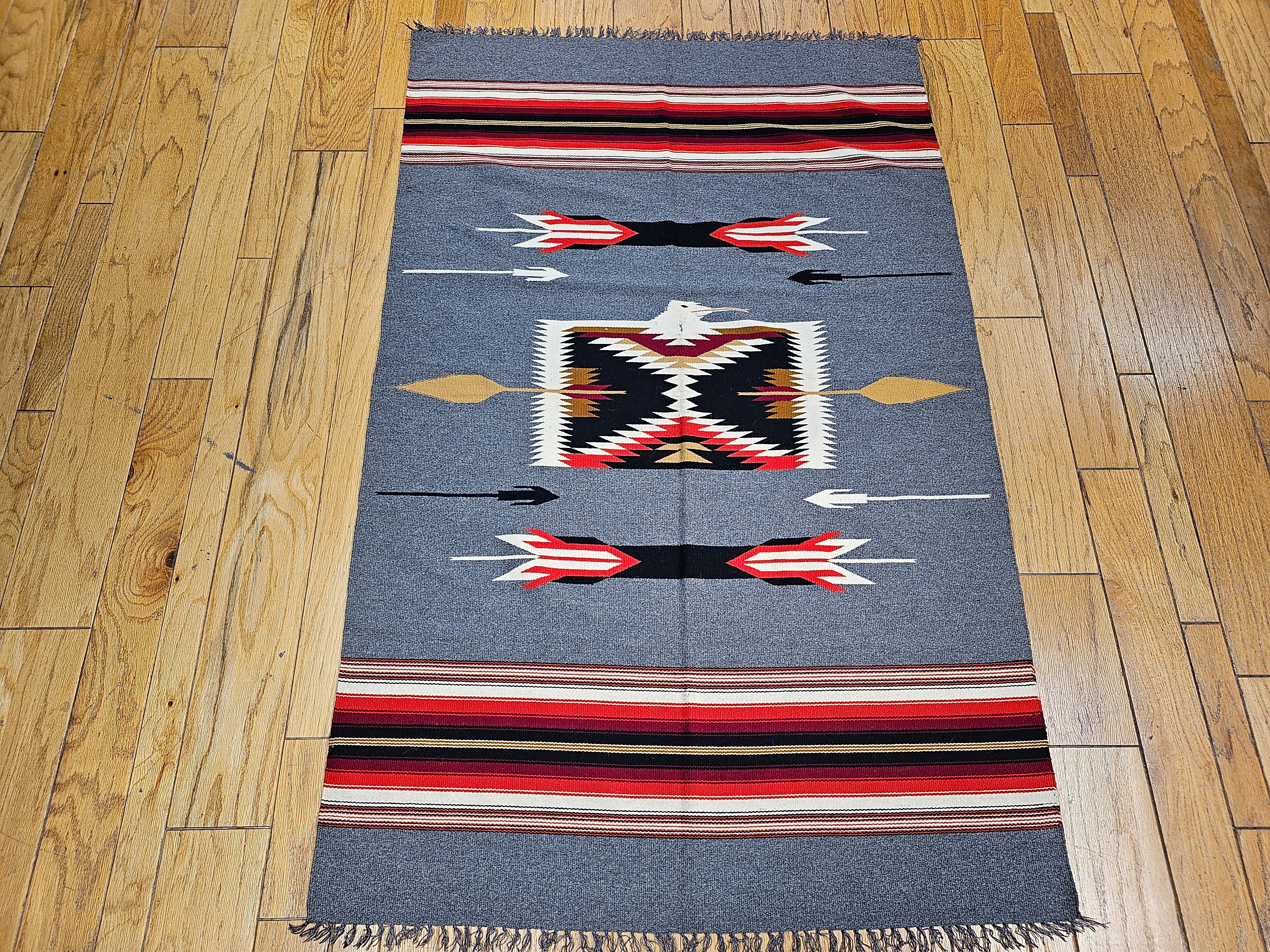 Vintage American southwestern kilim in a pale blue or Gray background from the late 1900s.    The very finely woven kilim has a beautiful pale blue or gray background color with stripes in the top and bottom of the kilim in red, ivory, black. There