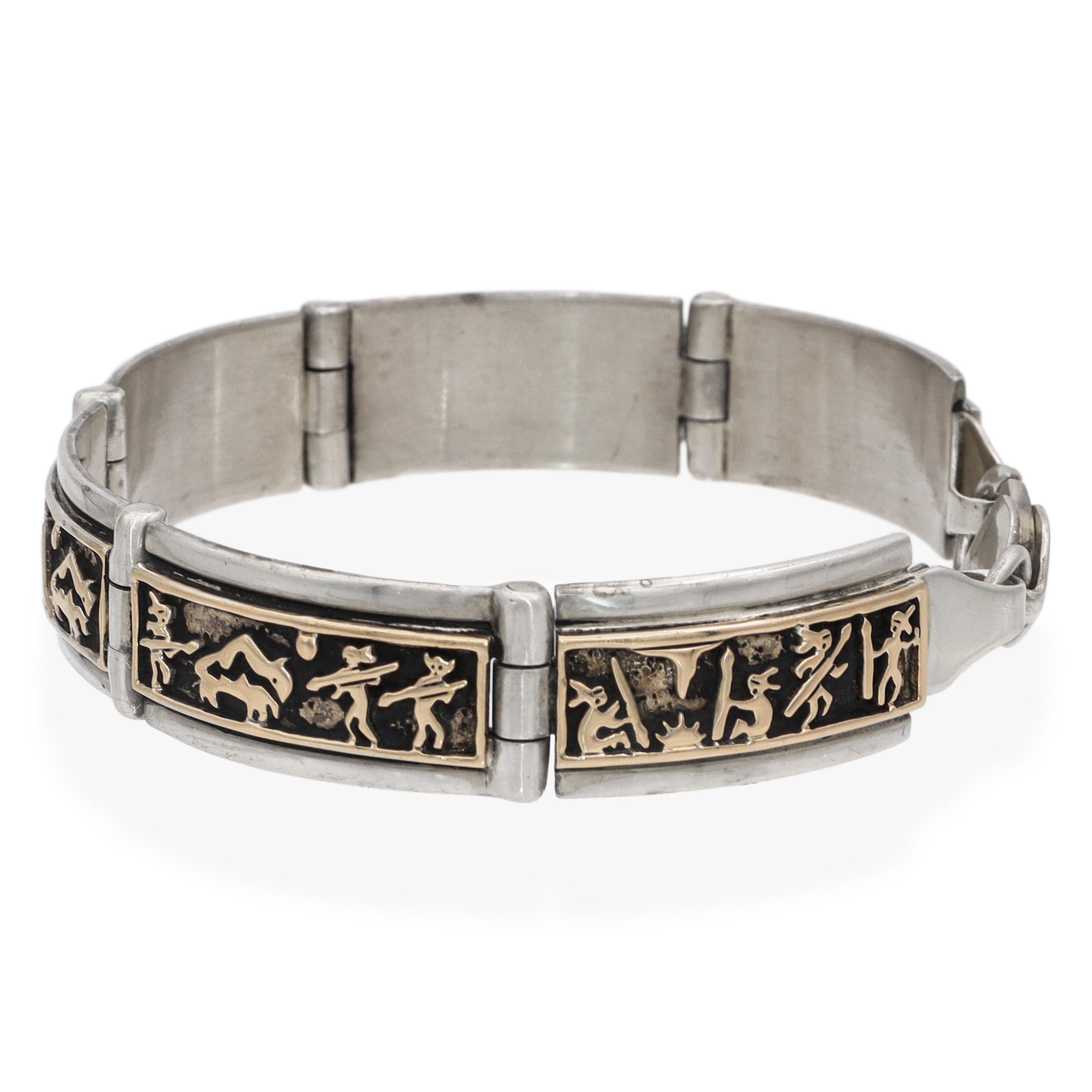 Un M&M finement élaboré. Bracelet à maillons Rogers Southwestern en argent sterling et en or 14 carats, avec des panneaux détaillés de style conteur. Chaque maillon rectangulaire incurvé est incrusté de figures et de motifs désertiques en or 14