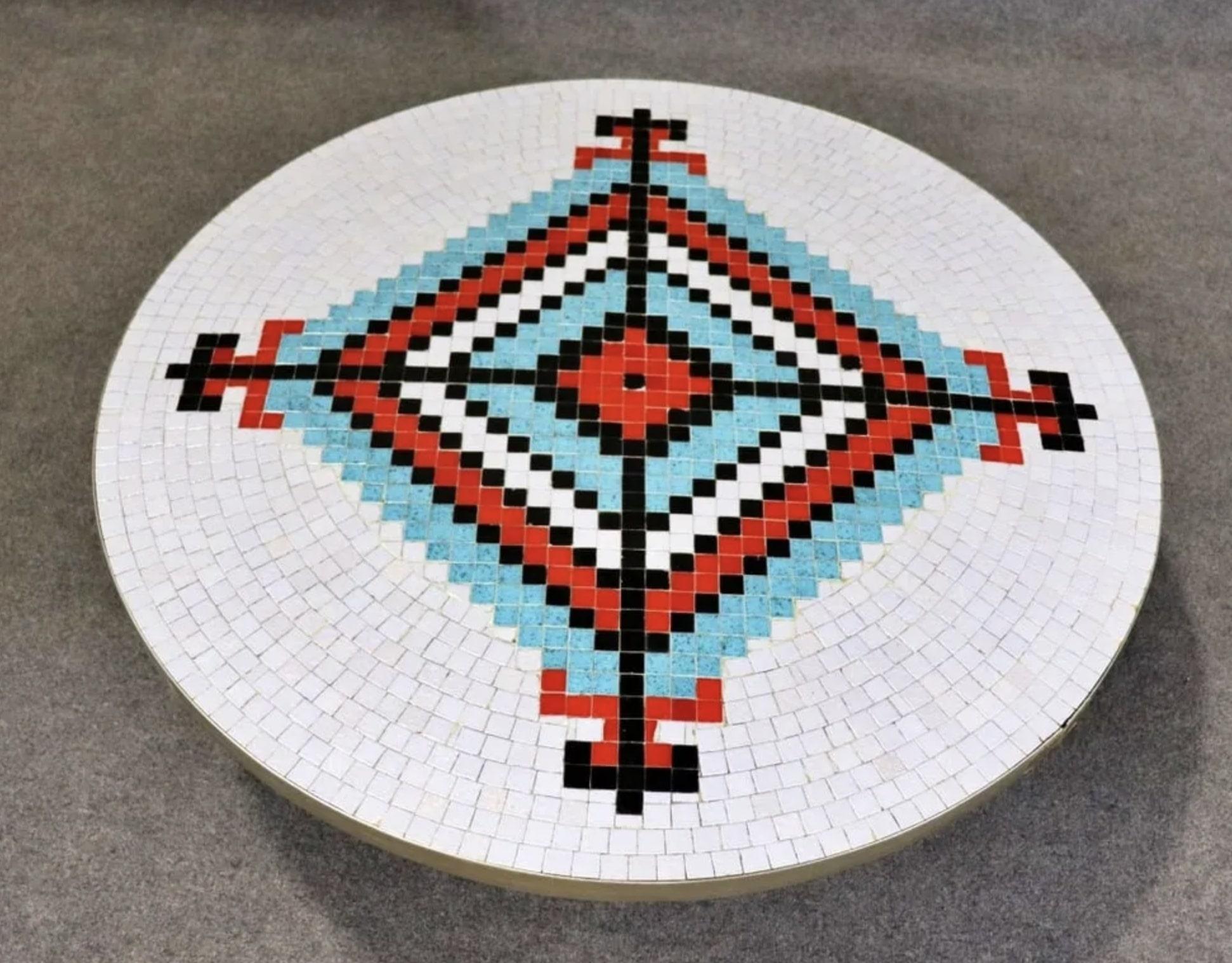 Round coffee table with tile design in American Indian motif. Tapered wood legs and brass trim.
Please confirm location NY or NJ