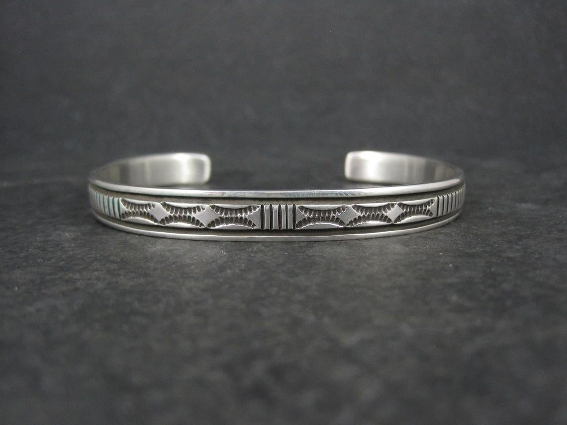 This beautiful Southwestern cuff bracelet is sterling silver.
It is a creation of Navajo silversmith Bruce Morgan.

Measurements: 1/4 of an inch wide - Inner circumference of 6 inches including the 1 inch gap.
Weight: 16.9 grams

Marks: B Morgan,